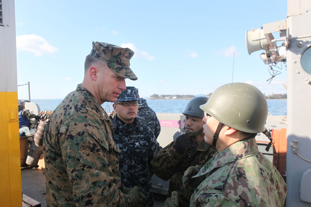 Lt. Col. William Arick, commanding officer, Combat Logistics Battalion 31, 31st Marine Expeditionary Unit (left); Petty Officer 2nd Class Zhong Yuan, Navy translator (second from left); Japanese Ground Self Defense Force Maj. Shinya Takase, operations officer, 1st Division, 41st Infantry Regiment, (second from right); and Capt. Masanori Ide, JGSDF liaison officer to the 31st MEU, talk about relief efforts aboard a U.S. Navy landing craft here, March 27. The 31st Marine Expeditionary Unit and Amphibious Squadron 11 picked up Japanese utility repair vehicles from the port here and delivered food, water, comfort items and the vehicles to residents on an isolated island.  The island of Oshima has been cut off from the mainland since the earthquake and tsunami March 11.  The operation demonstrated the MEU’s expeditionary capabilities in ship-to-shore amphibious operations. Marines and Sailors of the 31st MEU are conducting humanitarian aid and disaster relief missions in northeast Japan assisting the Japanese Self Defense Forces in their ongoing operations.
