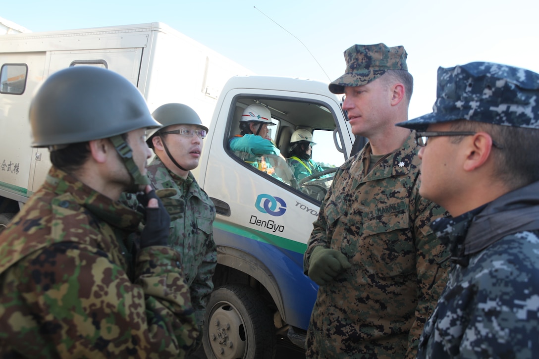 Japanese Ground Self Defense Force Maj. Shinya Takase, operations officer, 1st Division, 41st Infantry Regiment (left); Capt. Masanori Ide, JGSDF liaison officer to the 31st Marine Expeditionary Unit (second from left); Lt. Col. William Arick, commanding officer, Combat Logistics Battalion 31, 31st MEU (second from right) and Petty Officer 2nd Class Zhong Yuan, Navy translator, talk about relief efforts aboard a U.S. Navy landing craft here, March 27.  The 31st Marine Expeditionary Unit and Amphibious Squadron 11 picked up Japanese utility repair vehicles from the port in Kessenuma and delivered food, water, comfort items and the vehicles to residents on an isolated island.  The island of Oshima has been cut off from the mainland since the earthquake and tsunami March 11.  The operation demonstrated the MEU’s expeditionary capabilities in ship-to-shore amphibious operations. Marines and Sailors of the 31st MEU are conducting humanitarian aid and disaster relief missions in northeast Japan assisting the Japanese Self Defense Forces in their ongoing operations.