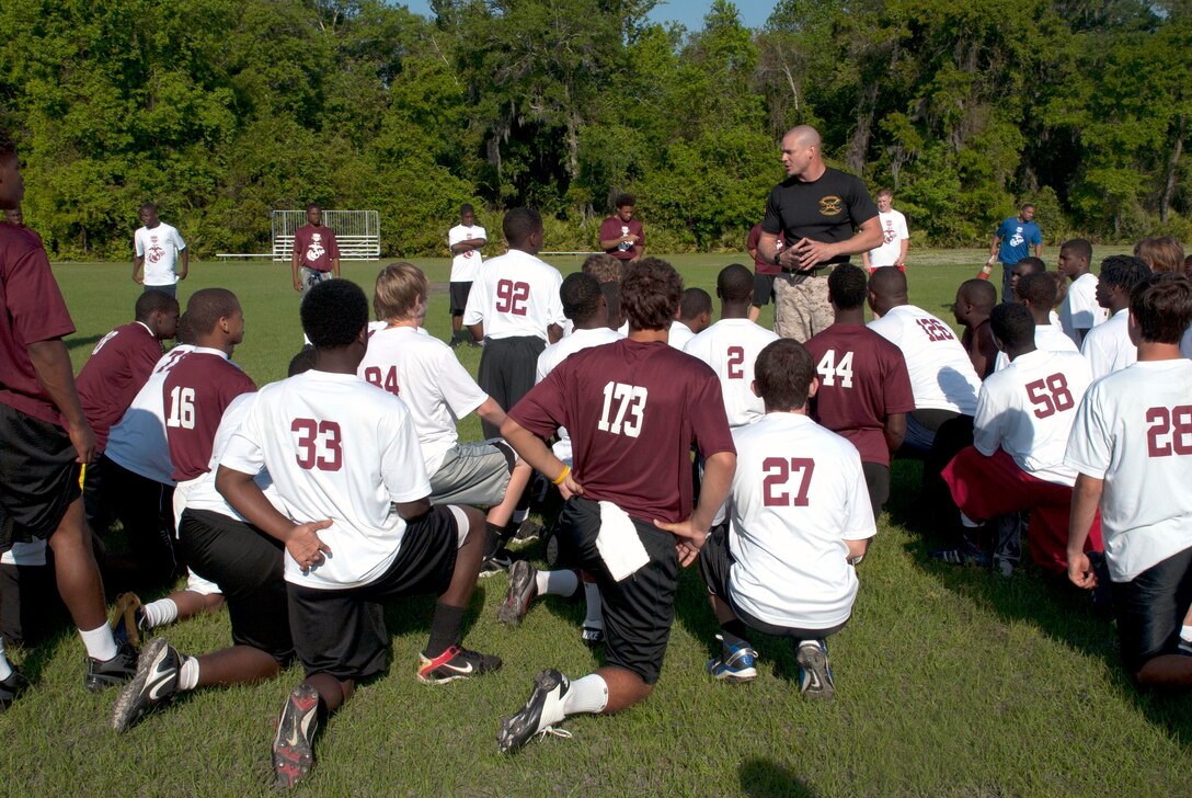 Staff Sgt. Christopher H. Miller, an instructor at the Drill Instructor School, Marine Corps Recruit Depot Parris Island, S.C., speaks to players attending the Junior Rank Diamond Flight football camp Mar. 25. High school juniors and seniors in attendance participated in leadership and character development training with Miller as part of the new “Proving Ground” component of the camp.