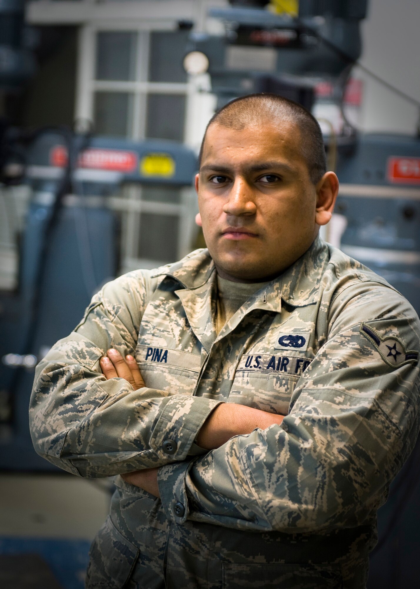 YOKOTA AIR BASE, Japan -- Airman Daniel Pina, 374th Maintenance Squadron metals technician, stands in front of machinery at the metals technology shop here March 26. Airman Pina worked extended hours on flanges for Japanese relief workers in support of Operation Tomodachi. (U.S. Air Force photo/Staff Sgt. Chad C. Strohmeyer)