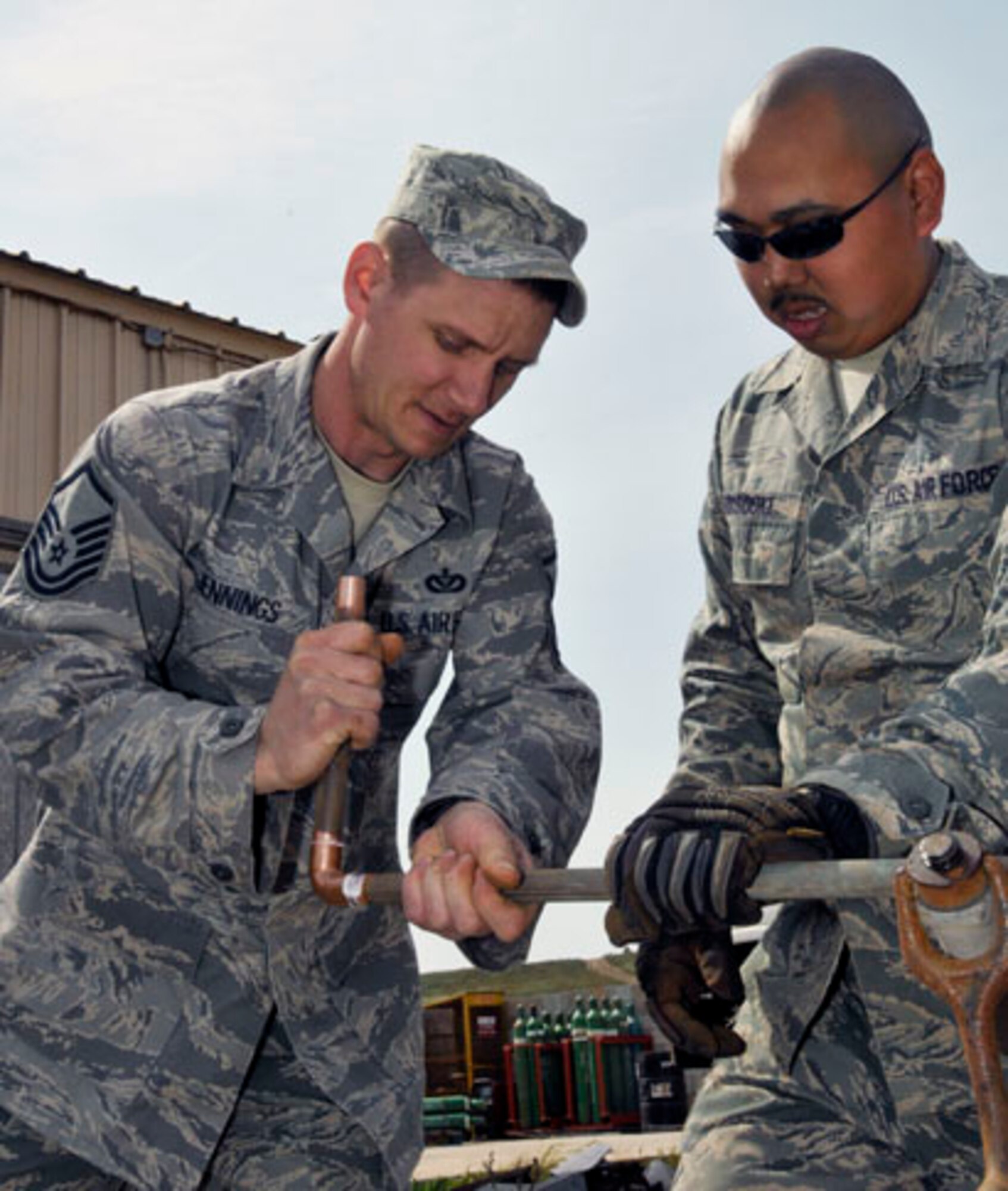 SAN CLEMENTE ISLAND, Calif. -- Master Sgt. Chad Jennings, the supervisor of the Heating, Ventilation, and Air Conditioning Section from the 176th Civil Engineer Squadron, teaches a junior member of his section about preparing pipes for soldering here March 17. The 176 CES, part of the Alaska Air National Guard's 176th Wing, deployed to San Clemente Island for two weeks in March 2011 to train and work on a variety of infrastructure projects. The pipes here were used to hook up a new air compressor. Alaska Air National Guard photo by Staff Sgt. N. Alicia Goldberger. 