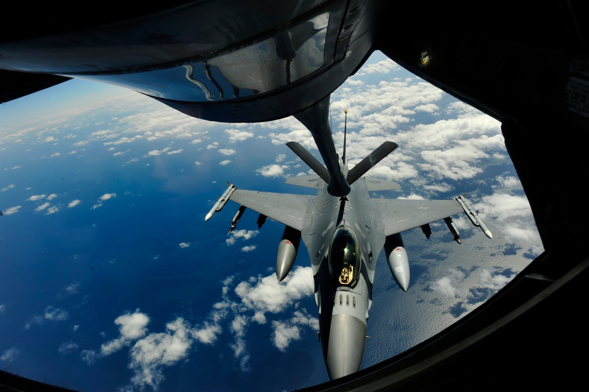 Airman 1st Class Derek Greene, an in-flight refueling technician, with the 909th Air Refueling Squadron, oversees the refueling of an F-16 Fighting Falcon from the 14th Fighter Squadron, Misawa Air Base, while flying over the Sea of Japan March 27.  The 14 FS is conducting a routine operational training deployment to Kunsan Air Base, Republic of Korea for the next few weeks. (U.S. Air Force photo/Staff Sgt. Lakisha A. Croley)