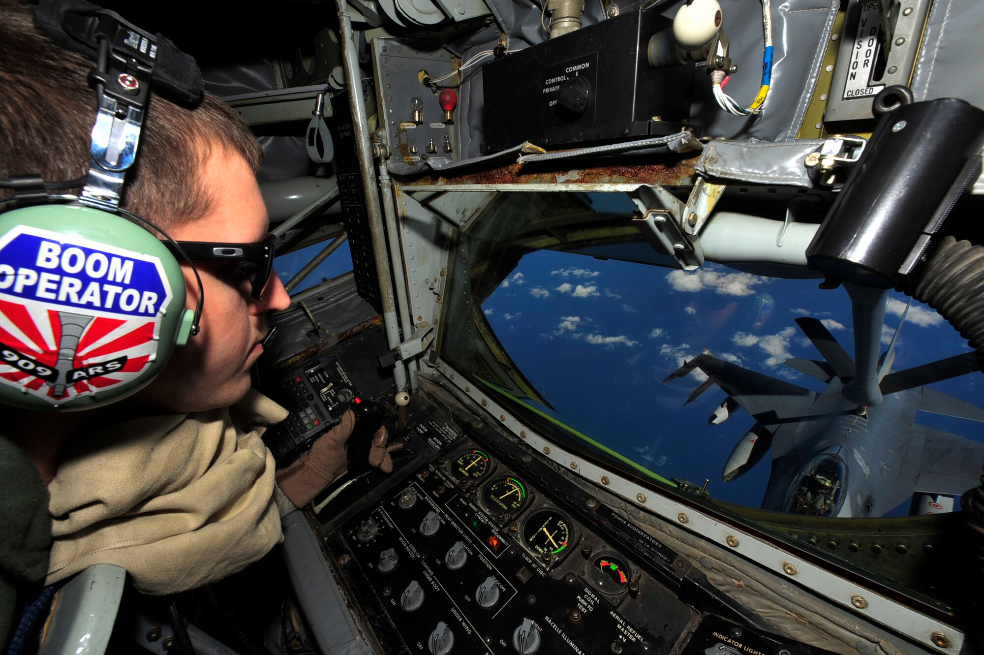 Airman 1st Class Derek Greene, an in-flight refueling technician, with the 909th Air Refueling Squadron, operates a boom aboard a KC-135 Stratotanker to deliver fuel to an F-16 Fighting Falcon from the 14th Fighter Squadron, Misawa Air Base, while flying over the Sea of Japan March 27. The KC-135 provides aerial refueling support to Air Force, Navy and Marine Corps aircraft as well as aircraft of allied nations. (U.S. Air Force photo/Staff Sgt. Lakisha A. Croley)