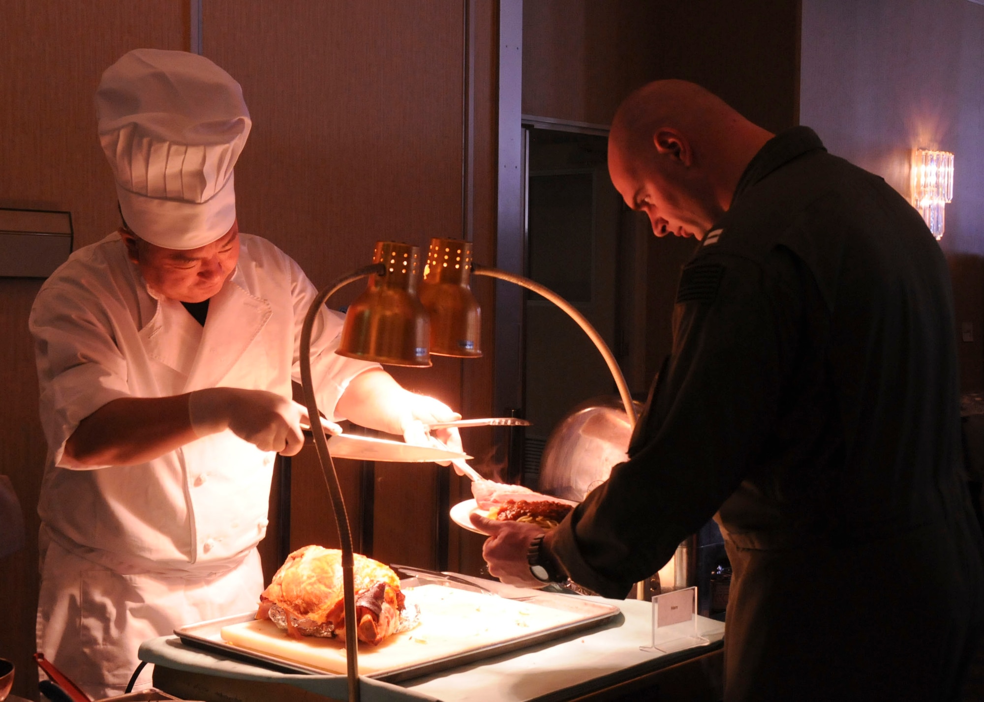MISAWA AIR BASE, Japan -- A U.S. Navy Sailor get some fresh-carved ham at the collocated club's Sunday brunch buffet March 27. Many base facilities are now returning to normal operations after a March 11 earthquake cut off power to the base for two days. (U.S. Air Force photo by Staff Sgt. Rachel Martinez/Released)