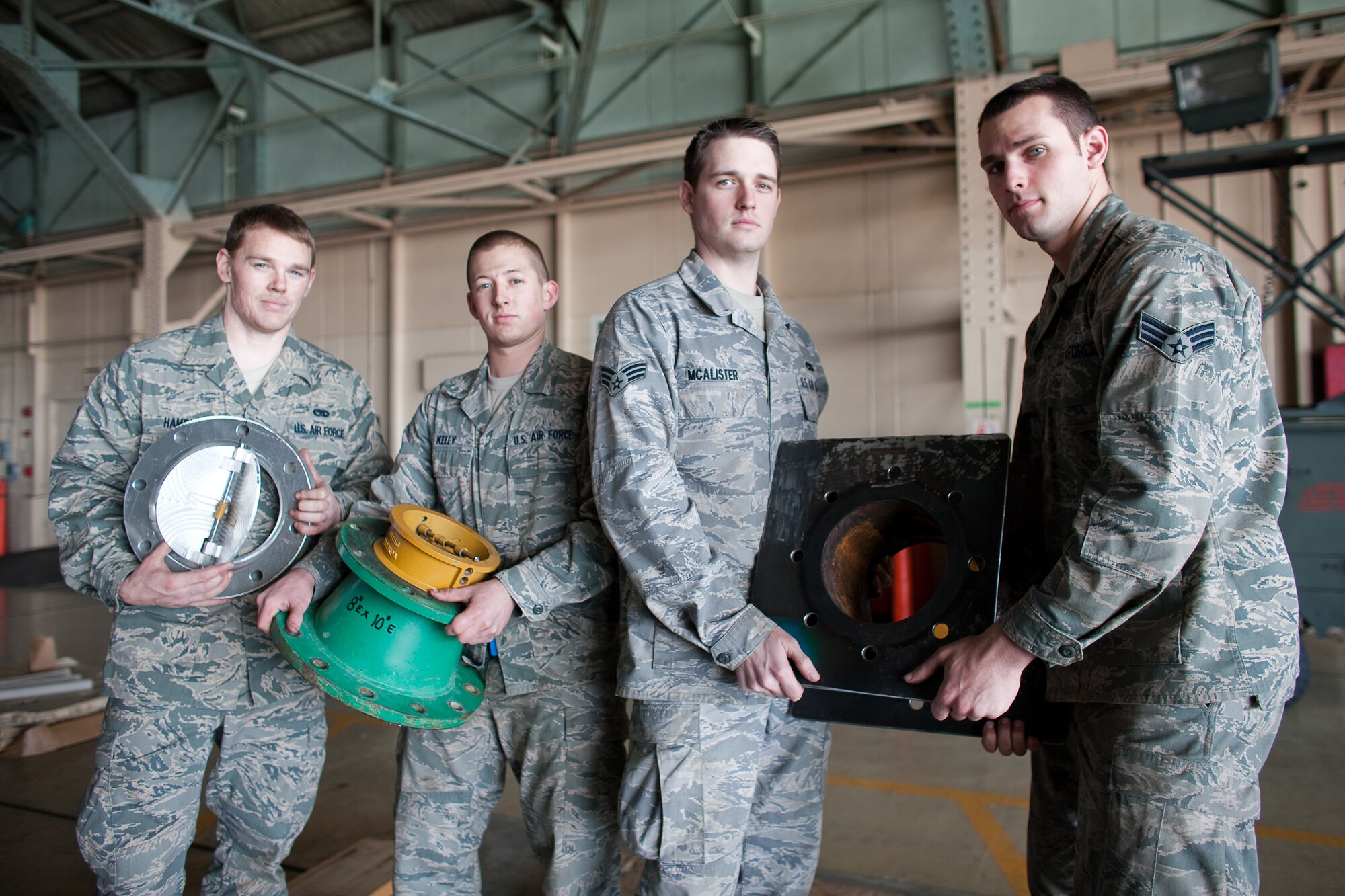 YOKOTA AIR BASE, Japan -- (Left to right) Airman 1st Class Jeremy Hamblin, Airman 1st Class William Kelly, Senior Airman Daniel McAlister, and Airman 1st Class Skyler Nefflen, 374th Maintenance Squadron aircraft metal technology shop, deliver a component for a water pump March 27, 2011. Two teams of four Airmen on 12-hour shifts designed and created the necessary adapters, pressure valves and other pieces so Japanese crews could use the pumps to augment the plant’s cooling system. The pumps will be used to transport fresh water into the plant instead of ocean water, which leaves corroding salt residue when it evaporates. The project is one more way Team Yokota has supported Operation Tomodachi, the overall relief mission to help the Japanese people in their recovery efforts.  (U.S. Air Force photo/Osakabe Yasuo)