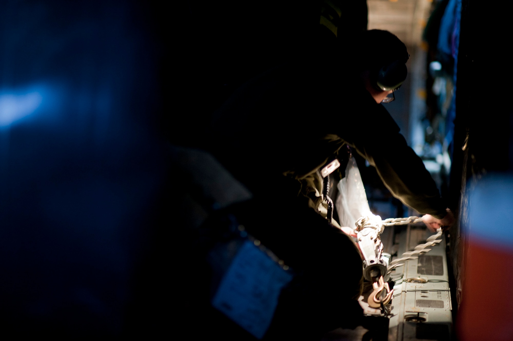 OVER JAPAN -- A loadmaster from the 353rd Special Operations Group checks the tiedowns on a container of diesel fuel aboard an MC-130P Combat Shadow March 28, 2011. The MC-130P carried fuel to Sendai Airport, where fuel is in high demand to power the heavy machinery clearing debris and making the airport usable again. (U.S. Air Force photo/Staff Sgt. Samuel Morse)
