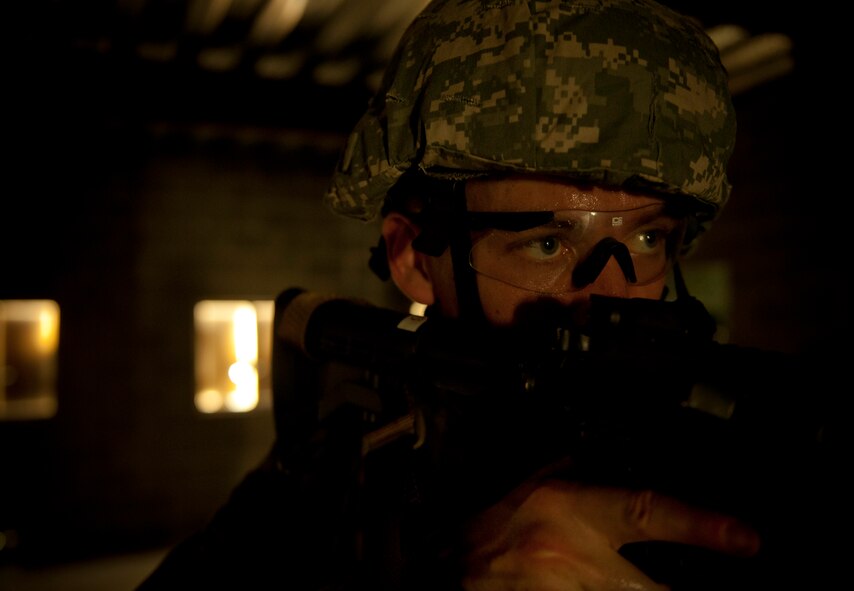 MOODY AIR FORCE BASE, Ga.-- Air Force ROTC cadet James Kearney, Cincinnati, Ohio, looks toward an open door while keeping watch during a combat portion of the air liaison officer training March 24. During the training, trainees were given multiple tasks to accomplish while keeping calm under pressure. (U.S. Air Force photo/Airman 1st Class Joshua Green)(RELEASED)
