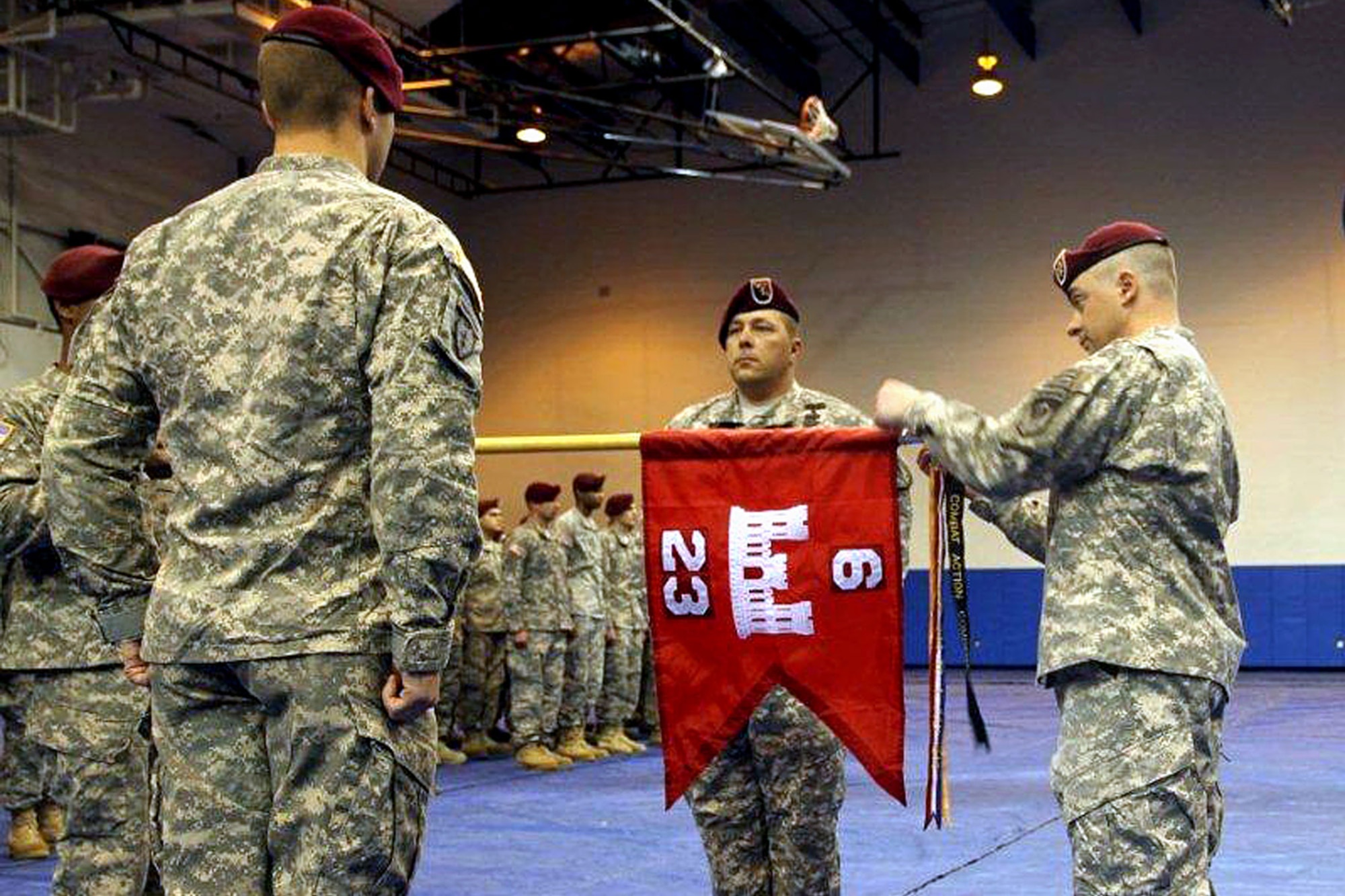 Army Lt. Col. Marc Hoffmeister, 6th Engineer Battalion commander, places a combat action streamer on the 23rd Engineer Company (Sapper) guidon, March 17, during a redeployment ceremony at the Buckner Physical Fitness Center. (U.S. Army photo/Sgt. Tamika Dillard)