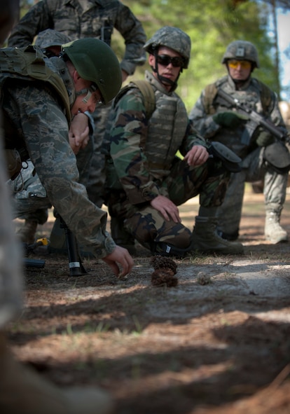 MOODY AIR FORCE BASE, Ga.-- Air Force ROTC Cadet William West, University of Kentucky, explains his team’s plan of action using lines in the dirt and pine cones simulating the military operations in urban terrain village training facility March 24. Before starting the mission, trainees had to explain to one of the cadre how they planned to get in and out of MOUT village with minimal casualties. (U.S. Air Force photo/Airman 1st Class Joshua Green)(RELEASED)

