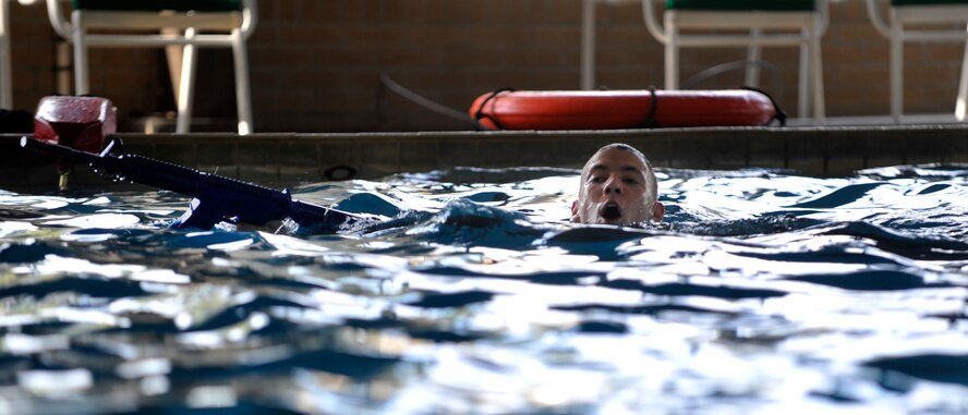 MOODY AIR FORCE BASE, Ga. -- A member of the air liaison officer assessment course swims across the water while keeping his rifle dry during the water confidence course March 23. The participants were involved in different activities that included swimming with their weapons and pushing their gear across the water while racing the other groups. (U.S. Air Force photo/Airman 1st Class Nicholas Benroth)(RELEASED)
