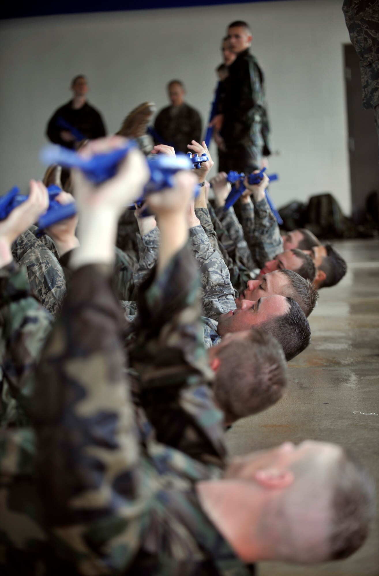 MOODY AIR FORCE BASE, Ga. -- A group of air liaison officer assessment participants hold their guns in the air as they perform leg lifts over the edge of the pool March 23. The participants had an hour of physical training after their two hours of water confidence training. (U.S. Air Force photo/Airman 1st Class Nicholas Benroth)(RELEASED)
