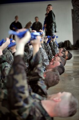 MOODY AIR FORCE BASE, Ga. -- A group of air liaison officer assessment participants hold their guns in the air as they perform leg lifts over the edge of the pool March 23. The participants had an hour of physical training after their two hours of water confidence training. (U.S. Air Force photo/Airman 1st Class Nicholas Benroth)