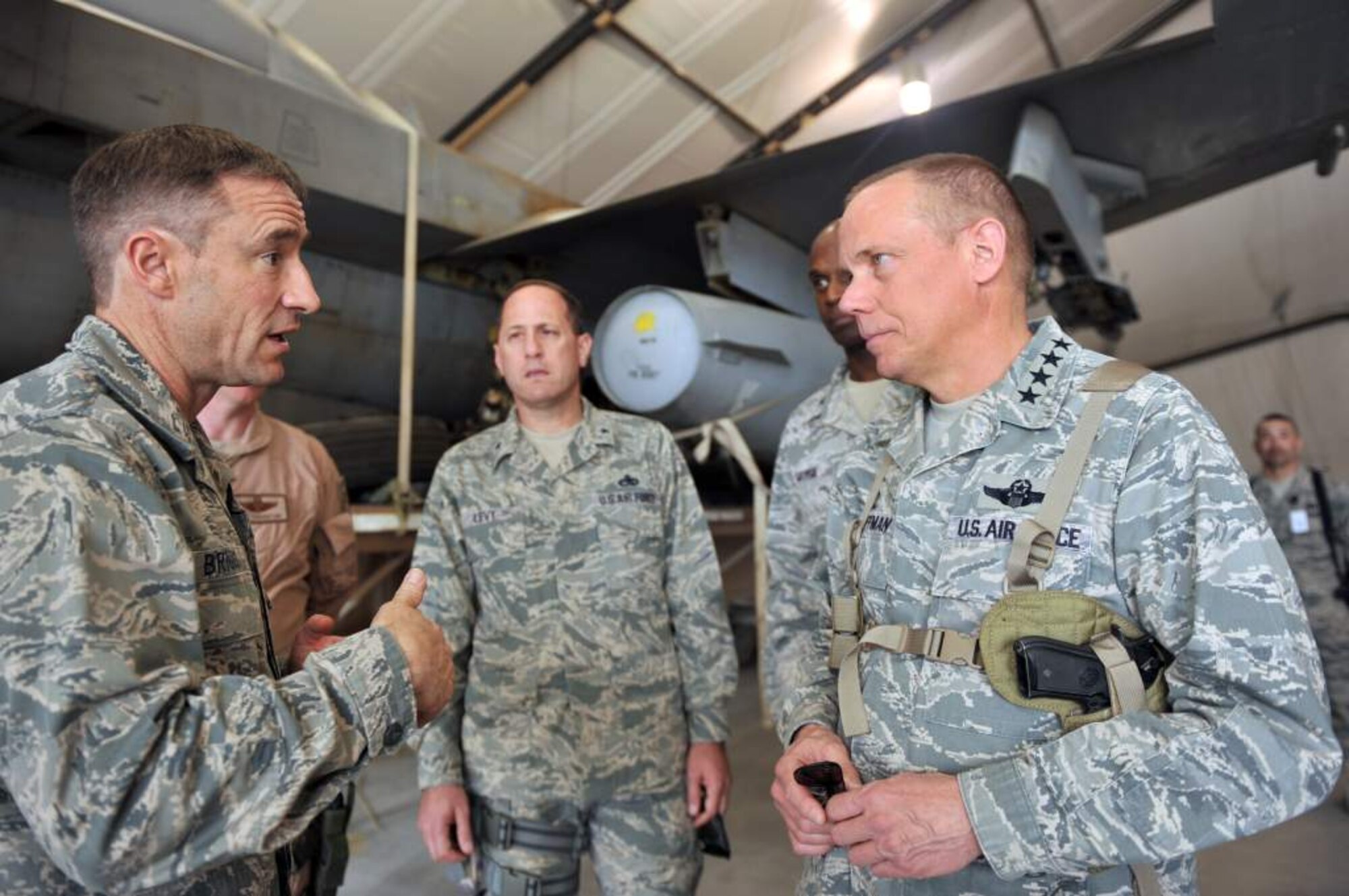 Brig. Gen. Jack Briggs, 455th Air Expeditionary Wing commander, briefs Gen. Donald Hoffman, Air Force Materiel Command commander, inside an F-16 Fighting Falcon hangar at Bagram Airfield, Afghanistan, March 18, 2011. General Hoffman is making this trip to acquire feedback directly from warfighters to determine how the command can better accomplish its supply and sustainment operations. (U.S. Air Force photo/Senior Airman Sheila deVera)