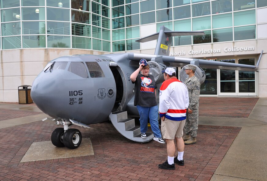 315th Airlift Wing mini C-17 demo team members Master Sgt. Michele Summers, Tech. Sgt. Nelson Irizarry and Tech. Sgt. Glenn Walker, all of the 315th Aircraft Maintenance Squadron, display the mini C-17 at the last home game of the regular season for the South Carolina Stingrays ECHL hockey team March 27. (U.S. Air Force photo by Capt. Wayne Capps)