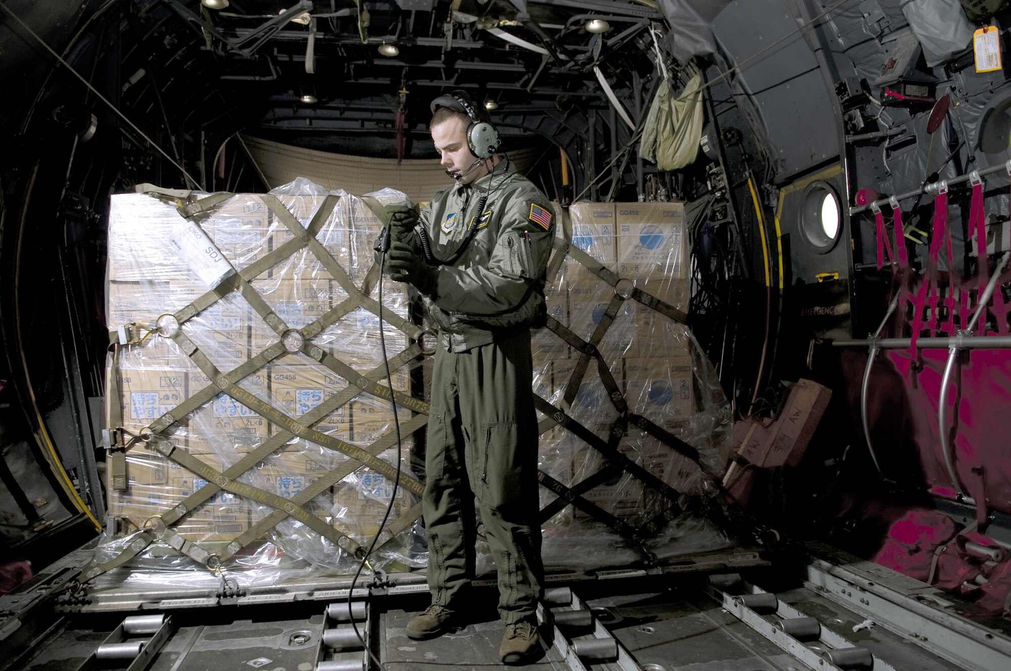Senior Airman Brandon Lee talks with the rest of the crew before unloading a pallet of water March 26, 2011, at Sendai Airport, Japan. The water that was airlifted to Sendai Airport is part of the more than 1.5 million pounds of water being moved from Yokota Air Base, Japan, to Northern Japan, in support of Operation Tomodachi. Lee is assigned to the 36th Airlift Squadron. (U.S. Air Force photo/Master Sgt. Jeromy K. Cross) 