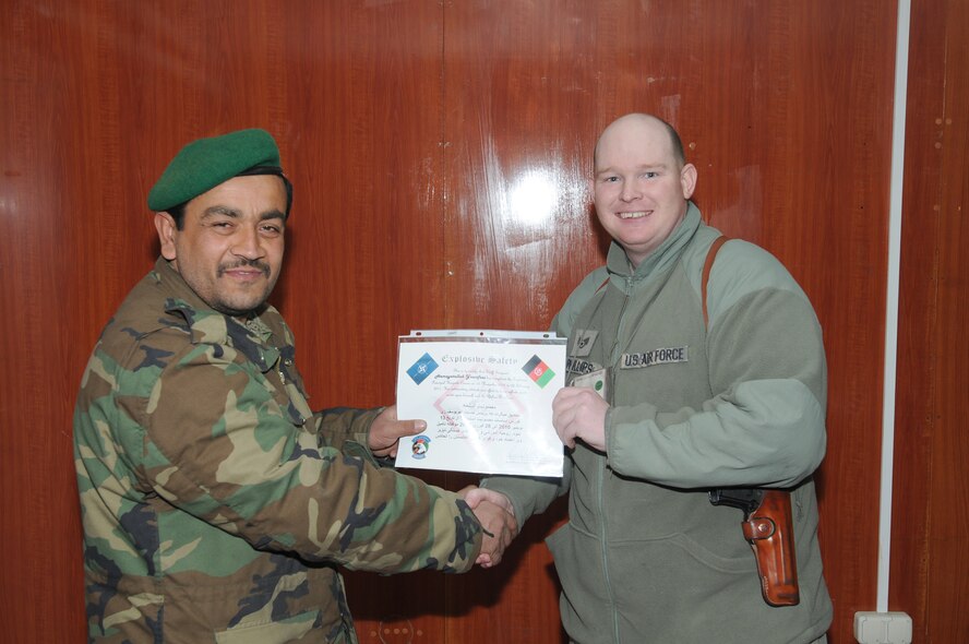 Afghan air force Sgt. Yosufzai Hamayattullah receives a certificate for graduating the two-month basic explosives hazards course March 15, 2011, at an AAF Base in Kabul, Afghanistan. Hamayattullah is the first weapons safety NCO in the AAF. (U.S. Navy photo/Petty Officer 2nd Class Vladimir Potapenko)