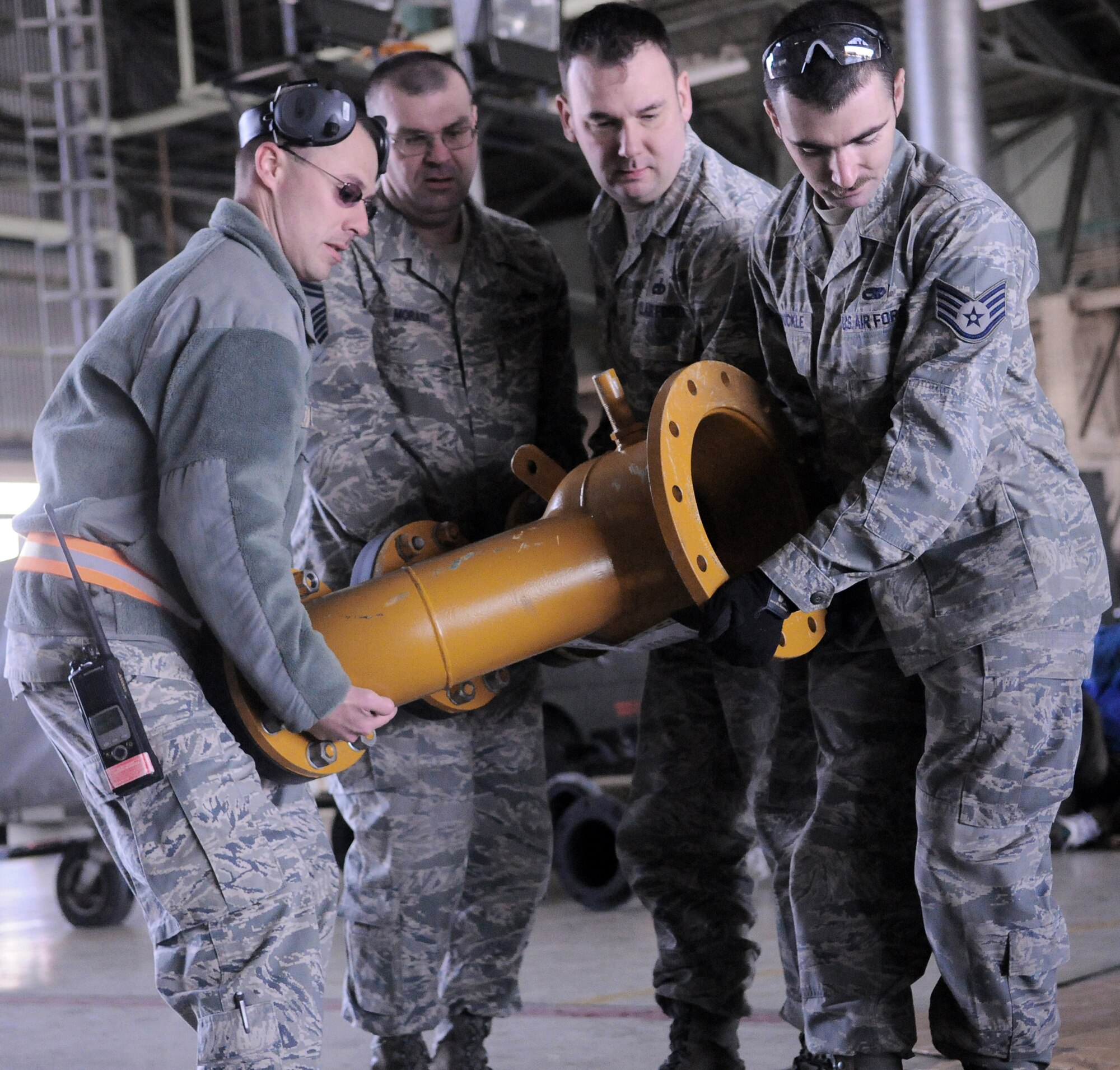 Airmen from the 374th Maintenance Squadron carry a custom made reduction flange March 26, 2011, at Yokota Air Base, Japan. Two teams of four Airmen on 12-hour shifts designed and created the necessary adapters, pressure valves and other pieces so Japanese crews can use a water pump -- donated by the U.S. government -- to augment the Fukushima nuclear plant's cooling system. The pump will be used to transport fresh water into the plant instead of ocean water, which leaves corroding salt residue when it evaporates.  (U.S. Air Force photo/Airman 1st Class Krystal M. Garrett) 

