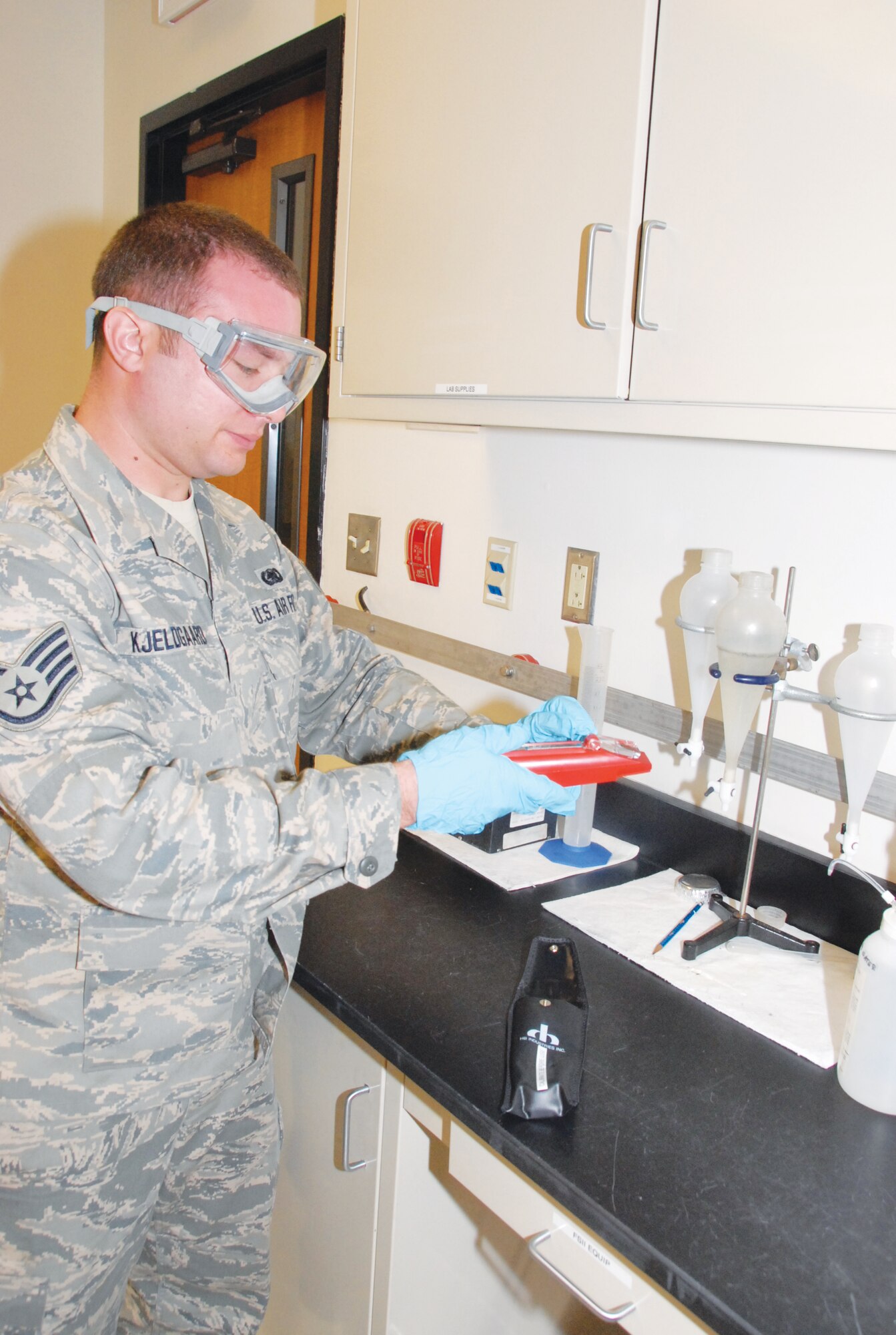 Staff Sgt. David Kjeldgaard uses a meter to determine the proper amount of additive in a fuel sample.  The Fuels Lab is charged with performing regular checks on gasoline, diesel fuel and jet fuel. U.S. Air Force Photo by Wayne Crenshaw
