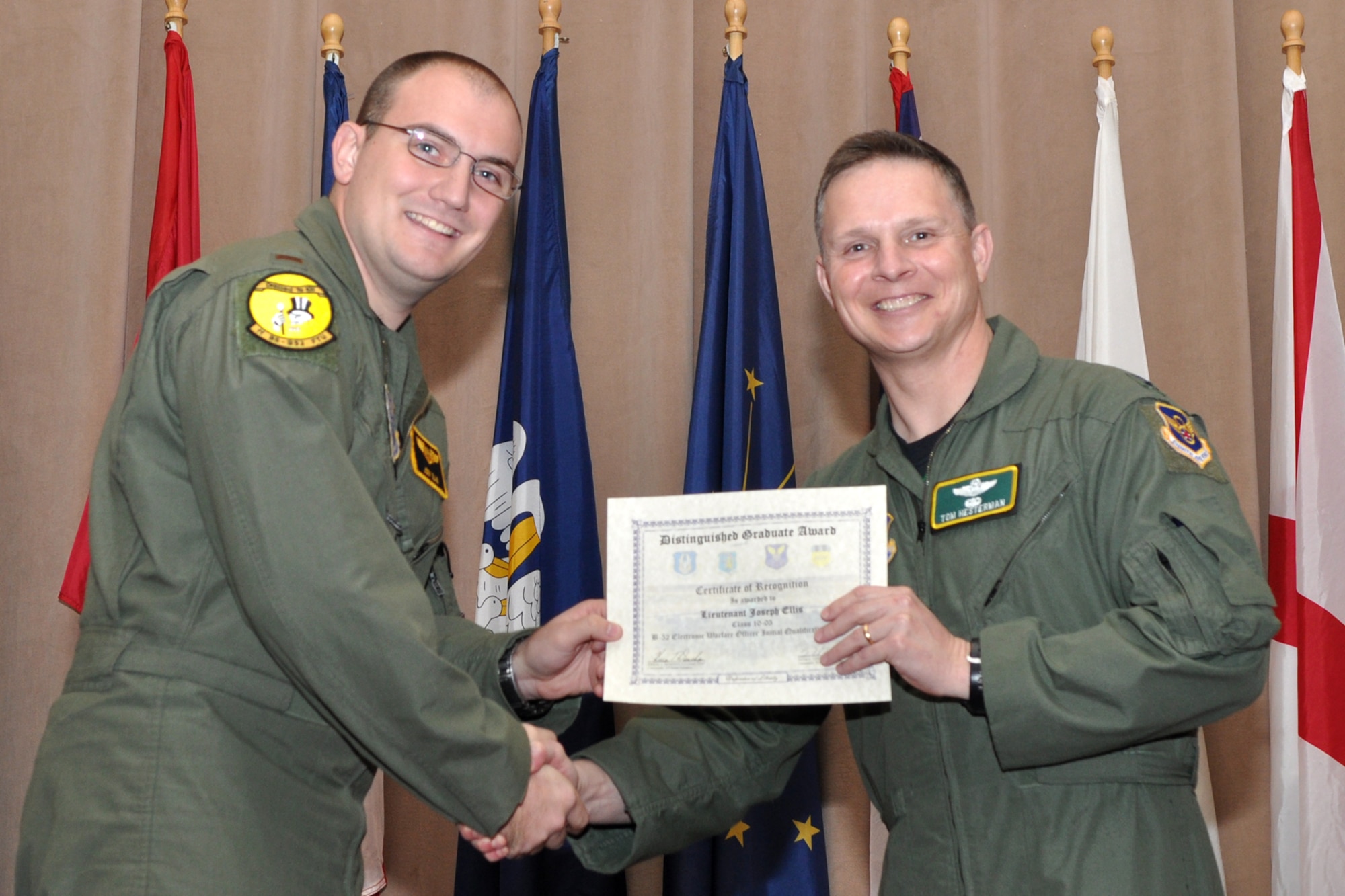 The Electronic Warfare Officer Distinguished Graduate for Formal Training Unit Class 10-03, 2nd Lt. Joseph Ellis, poses for a photo with Col. Thomas P. Hesterman, the 2nd Bomb Wing vice commander, during graduation ceremonies in Hoban Hall at Barksdale Air Force Base, La., March 11, 2011. The Distinguished Graduate Award is a culmination of academics tests, flight evaluation, officership, attitude and professional bearing. Students selected for the award have demonstrated a level of performance that is clearly above their peers.  Graduates of the 93rd Bomb Squadron's Formal Training Unit covered several aspects of B-52H Stratofortress operations during their training, which lasted approximately two years. The FTU is in charge of training Airmen to fly the B-52.  To accomplish this task of forging new aviators into Combat Ready B-52 crewmembers takes the work of both AF Reserve and Active Duty Members. Twenty-four students graduated from Class 10-03 and will now report for duty to squadrons throughout the B-52 community. (U.S. Air Force photo/Tech. Sgt. Jeff Walston)