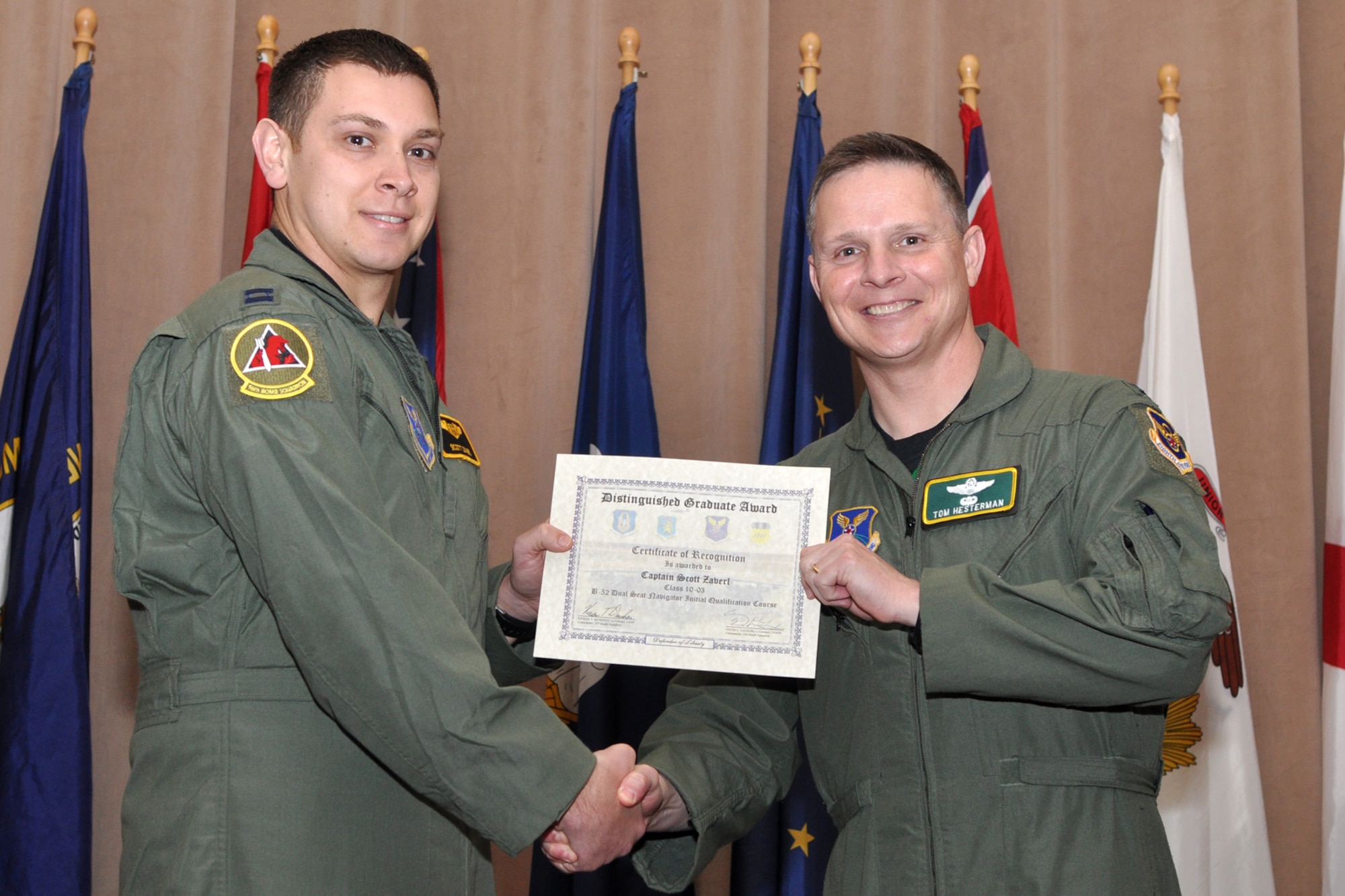 The Dual Seat Navigator Distinguished Graduate for Formal Training Unit Class 10-03, Capt. Scott Zaverl, poses for a photo with Col. Thomas P. Hesterman, the 2nd Bomb Wing vice commander, during graduation ceremonies in Hoban Hall at Barksdale Air Force Base, La., March 11, 2011. The Distinguished Graduate Award is a culmination of academics tests, flight evaluation, officership, attitude and professional bearing. Students selected for the award have demonstrated a level of performance that is clearly above their peers.  Graduates of the 93rd Bomb Squadron's Formal Training Unit covered several aspects of B-52H Stratofortress operations during their training, which lasted approximately two years. The FTU is in charge of training Airmen to fly the B-52.  To accomplish this task of forging new aviators into Combat Ready B-52 crewmembers takes the work of both AF Reserve and Active Duty Members. Twenty-four students graduated from Class 10-03 and will now report for duty to squadrons throughout the B-52 community. (U.S. Air Force photo/Tech. Sgt. Jeff Walston)
