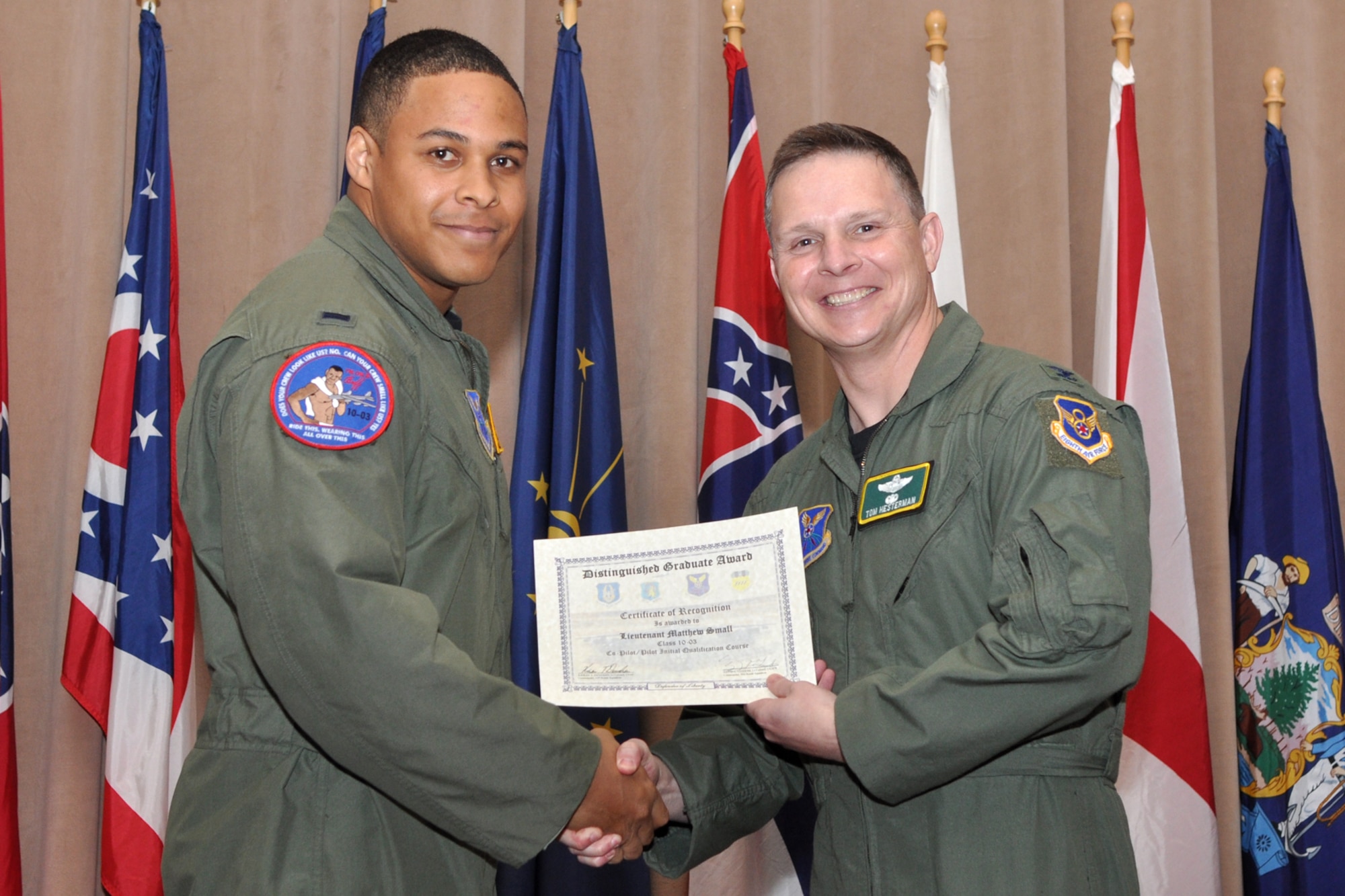 Copilot Distinguished Graduate for Formal Training Unit Class 10-03, 1st Lt. Matthew Small, poses for a photo with Col. Thomas P. Hesterman, the 2nd Bomb Wing vice commander, during graduation ceremonies in Hoban Hall at Barksdale Air Force Base, La., March 11, 2011. The Distinguished Graduate Award is a culmination of academics tests, flight evaluation, officership, attitude and professional bearing. Students selected for the award have demonstrated a level of performance that is clearly above their peers.  Graduates of the 93rd Bomb Squadron's Formal Training Unit covered several aspects of B-52H Stratofortress operations during their training, which lasted approximately two years. The FTU is in charge of training Airmen to fly the B-52.  To accomplish this task of forging new aviators into Combat Ready B-52 crewmembers takes the work of both AF Reserve and Active Duty Members. Twenty-four students graduated from Class 10-03 and will now report for duty to squadrons throughout the B-52 community. (U.S. Air Force photo/Tech. Sgt. Jeff Walston)
