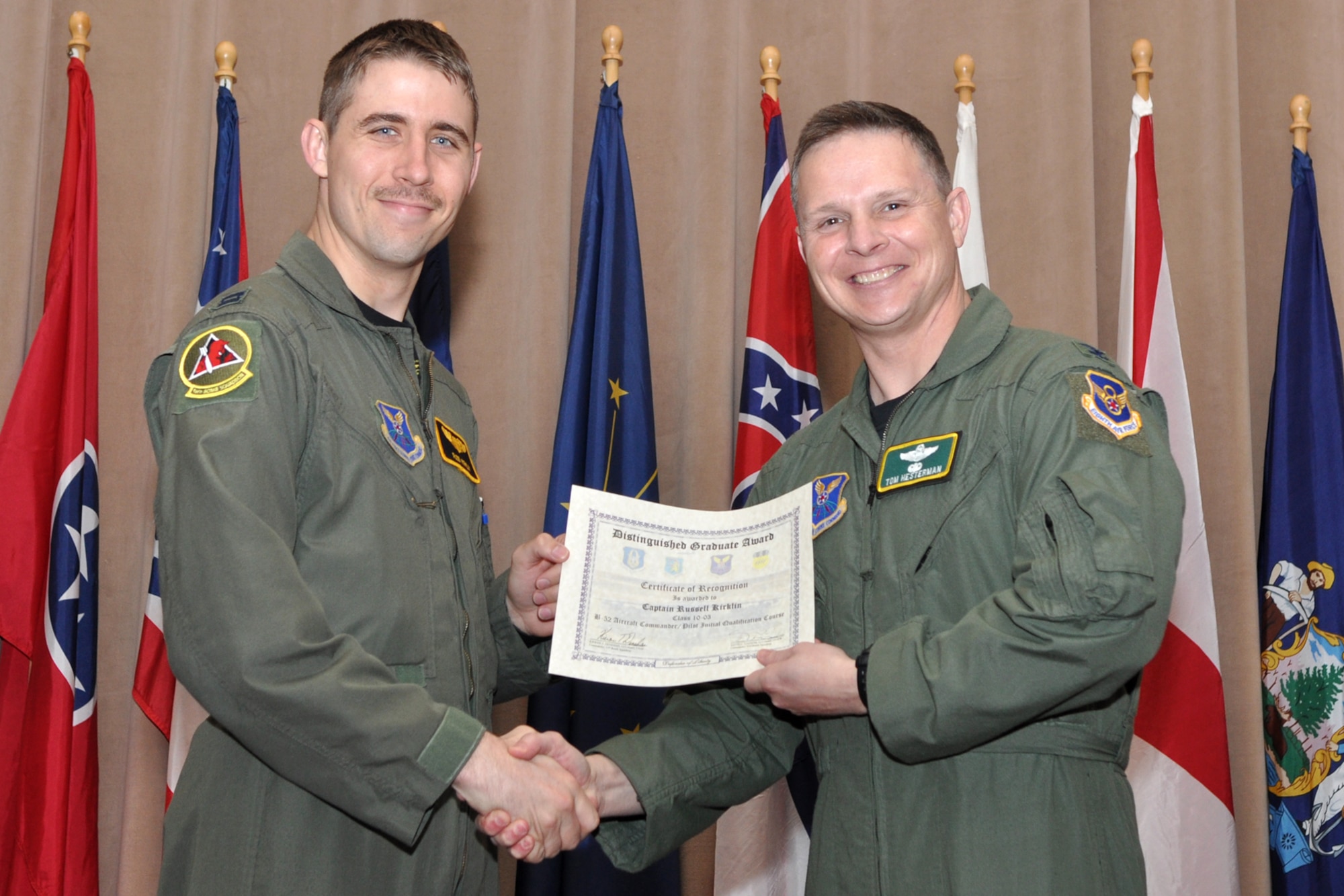 Capt. Russel Kirklin, a Pilot Distinguished Graduate for Formal Training Unit Class 10-03, poses for a photo with Col. Thomas P. Hesterman, the 2nd Bomb Wing vice commander, during graduation ceremonies in Hoban Hall at Barksdale Air Force Base, La., March 11, 2011. The Distinguished Graduate Award is a culmination of academics tests, flight evaluation, officership, attitude and professional bearing. Students selected for the award have demonstrated a level of performance that is clearly above their peers.  There is usually only one awarded for each specialty. Class 10-03 had a tie between two students for Aircraft Commander (Pilot) DG. Captain Kirklin tied for the award with Capt. Nicole Redmond. Graduates of the 93rd Bomb Squadron's Formal Training Unit covered several aspects of B-52H Stratofortress operations during their training, which lasted approximately two years. The FTU is in charge of training Airmen to fly the B-52.  To accomplish this task of forging new aviators into Combat Ready B-52 crewmembers takes the work of both AF Reserve and Active Duty Members. Twenty-four students graduated from Class 10-03 and will now report for duty to squadrons throughout the B-52 community. (U.S. Air Force photo/Tech. Sgt. Jeff Walston)