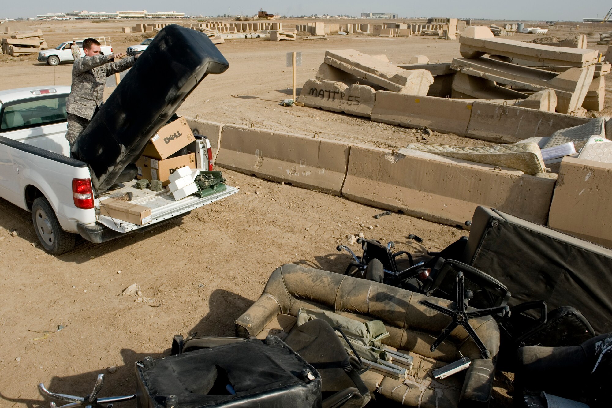 SATHER AIR BASE, Iraq -- Tech. Sgt. Eric Cicogna, 447th Expeditionary Communications Squadron, unloads bulk garbage items to throw into a dump site March 19. The collection point was set up in conjunction with "Operation Clean Sweep," which was an effort to reduce bulk trash on base in anticipation of relocating forces at the end of the year. Sergeant Cicogna is deployed from the 628th Communications Squadron, Joint Base Charleston, S.C., and is a native of Lawrenceville, N.J. (U.S. Air Force photo by Staff Sgt. Levi Riendeau)