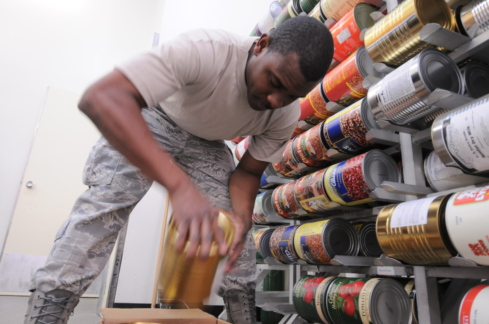 YOKOTA AIR BASE, Japan -- Staff Sgt. Vernon Rogers, 374th Force Support Squadron augmentee from Andersen Air Base, Guam, stores canned items in the Samurai Cafe, March 23, 2011. Due to the influx of temporary deployed military personnel here to support Operation Tomodachi, the Samurai has increased work hours and food supply. (U.S. Air Force photo/Airman 1st Class Krystal M. Garrett)  