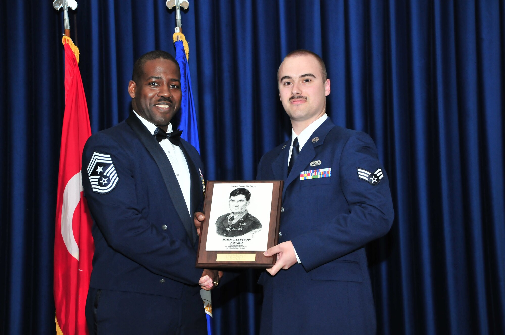 Chief Master Sgt. Marcus Snoddy, the 39th Air Base Wing command chief, presents the John L. Levitow Award to Senior Airman Scott Adams, from the 728th Air Mobility Squadron, during the Airman Leadership School graduation for class 11-4 in the Club Complex March 18, 2011, at Incirlik Air Base, Turkey. The Levitow Award is the pinnacle achievement for enlisted Airmen enrolled in professional military education in the U.S. Air Force. It is awarded to the top graduate at each level of PME: ALS, NCO academy and Senior NCO Academy. There is only one Levitow Award given in each class. (U.S. Air Force photo by Staff Sgt. Alexandre Montes/Released)