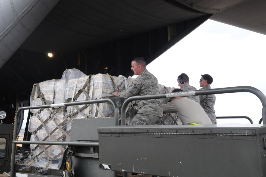 YOKOTA AIR BASE, Japan -- Airmen from the 730th Air Mobility Squadron load cargo on to a C-130 Hercules here March 27. The supplies will be used in support for Operation Tomodachi. (U.S. Air Force photo/Amn John D. Partlow)