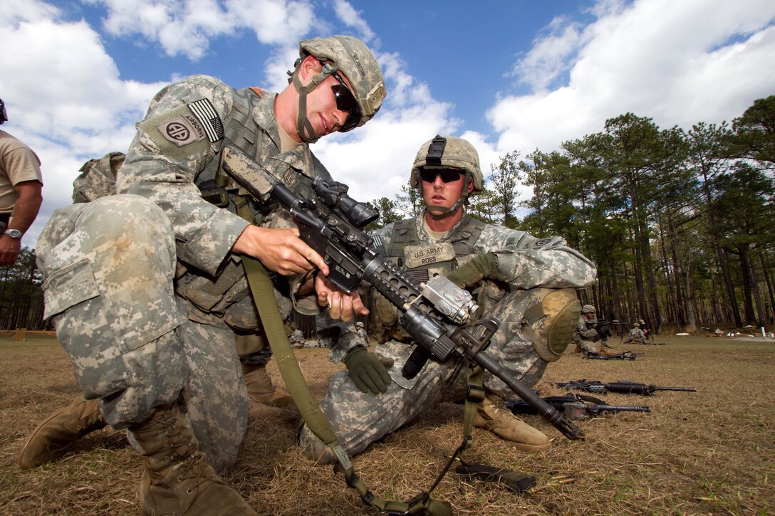 U.S. Army 1st Lt. Preston Patton, left, shows another U.S. Army paratrooper how to correct a malfunction in his M-4 carbine during an advanced rifle marksmanship course on Fort Bragg, N.C., March 24, 2011. 