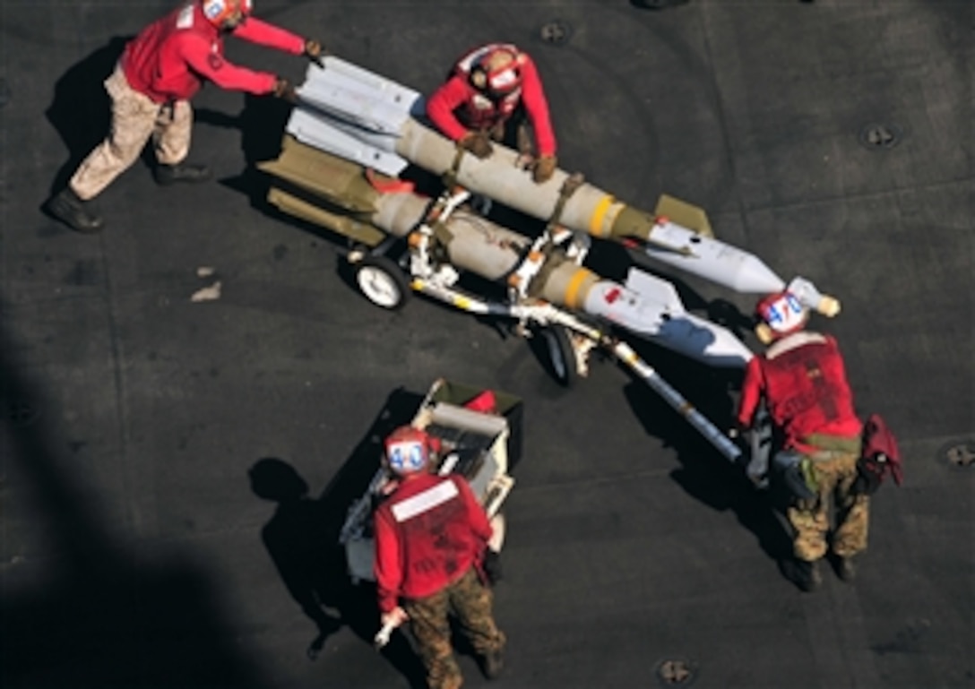 Marines assigned to the aircraft carrier USS Enterprise (CVN 65) push ordnance into place to arm an F/A-18C Hornet assigned to Attack Squadron 251 while underway in the Arabian Sea on March 26, 2011.  The Enterprise and Carrier Air Wing 1 are conducting maritime security operations and close-air support missions for Operation Enduring Freedom in the U.S. 5th Fleet area of responsibility.  