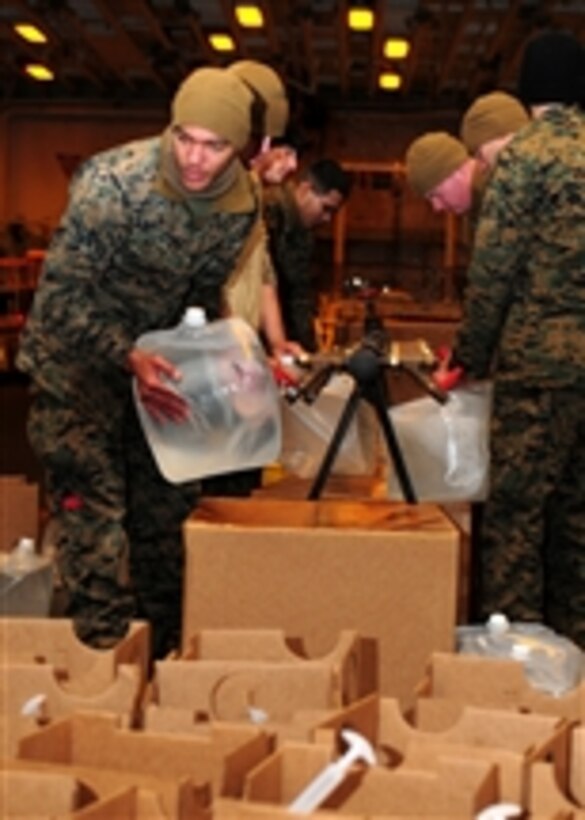 U.S. Marines assigned to the 31st Marine Expeditionary Unit fill plastic containers with potable water in the hangar bay of amphibious assault ship USS Essex (LHD 2) in the Pacific Ocean on March 25, 2011.  The water was transported to various locations in Japan as a part of Operation Tomodachi.  The Essex and the dock landing ships USS Harpers Ferry (LSD 49) and USS Germantown (LSD 42), along with the embarked 31st Marine Expeditionary Unit were operating off the coast of Hachinohe in northeastern Japan.  
