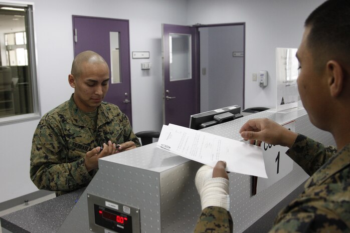 Lance Cpl. Cesar Tierrablanca, a station Air Terminal passenger service agent, provides assistance to Lance Cpl. Carlos Monroy, a Marine Fighter Attack Squadron 314 powerline mechanic, here March 29. Passenger service agents from the Passenger Service Center make sure passengers::r::::n::are taken care of and get to where they need to be.