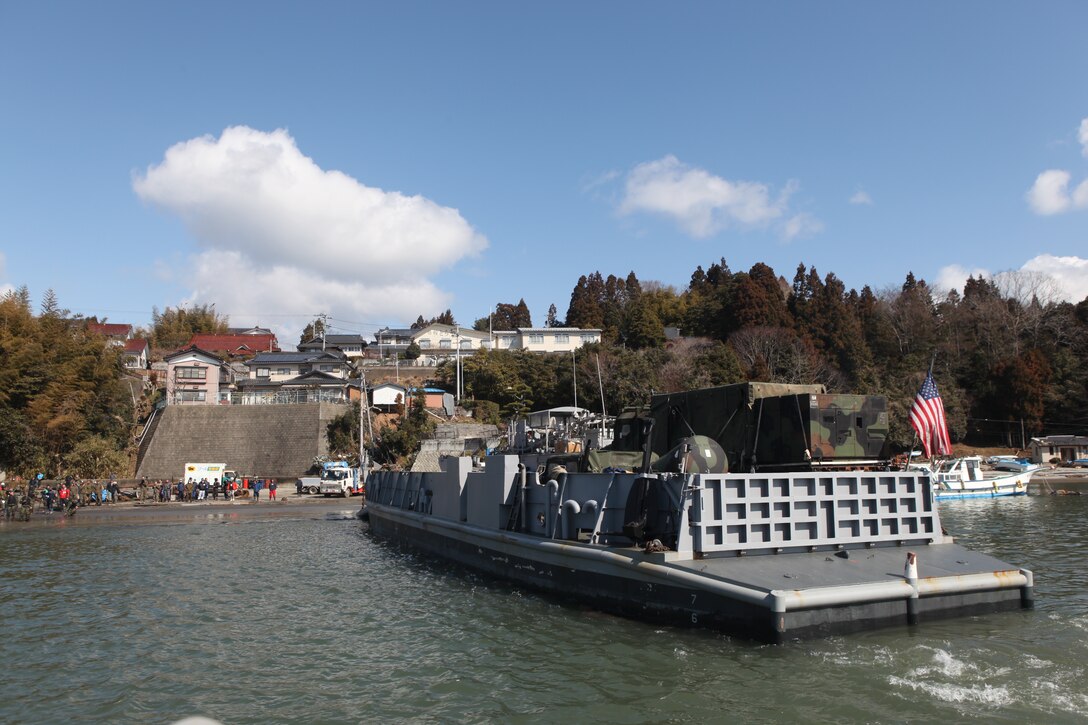 A U.S. Navy landing craft docks near a devastated area here, March 27.  The 31st Marine Expeditionary Unit and Amphibious Squadron 11 picked up Japanese utility repair vehicles from the port in Kessenuma and delivered food, water, comfort items and the vehicles to residents on this isolated island.  The island of Oshima has been cut off from the mainland since the earthquake and tsunami March 11.  The operation demonstrated the MEU’s expeditionary capabilities in ship-to-shore amphibious operations. Marines and Sailors of the 31st MEU are conducting humanitarian aid and disaster relief missions in northeast Japan assisting the Japanese Self Defense Forces in their ongoing operations.