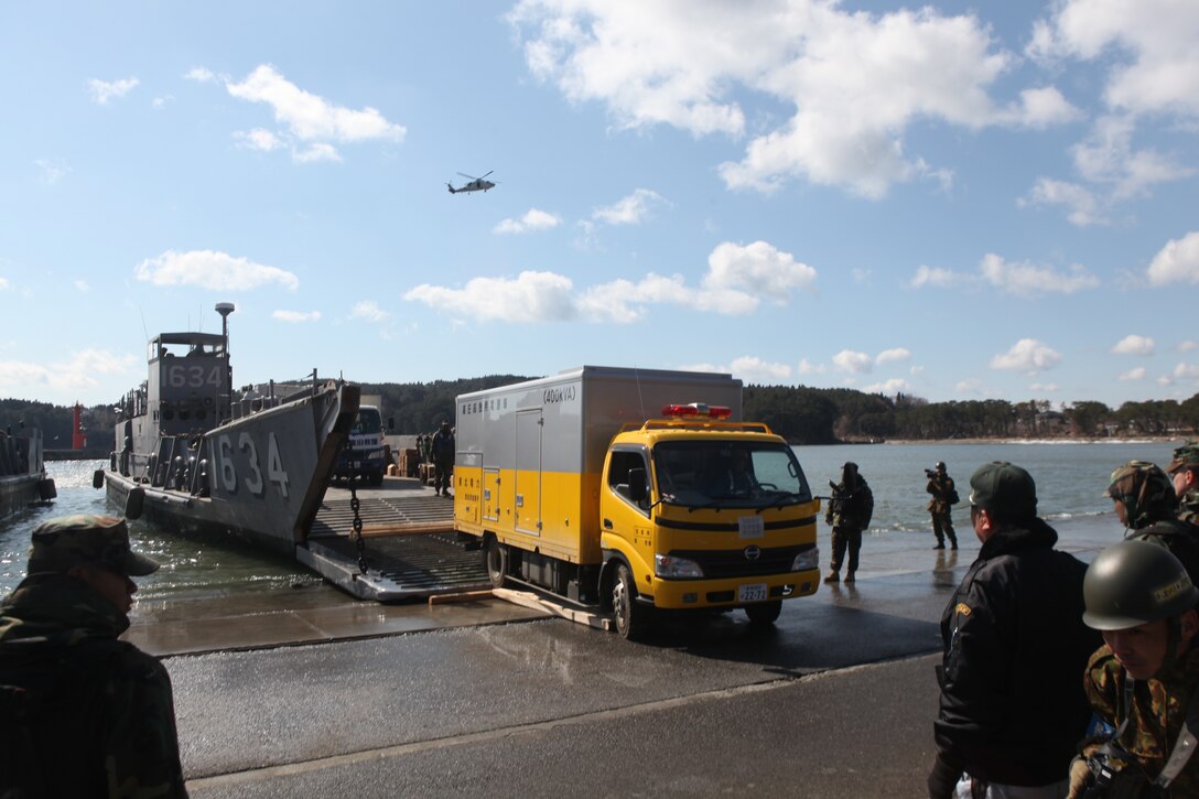 A Japanese utility repair vehicle drives off a U.S. Navy landing craft docked here, March 27.  The 31st Marine Expeditionary Unit and Amphibious Squadron 11 picked up Japanese utility repair vehicles from the port in Kessenuma and delivered food, water, comfort items and the vehicles to residents on this isolated island.  The island of Oshima has been cut off from the mainland since the earthquake and tsunami March 11.  The operation demonstrated the MEU’s expeditionary capabilities in ship-to-shore amphibious operations. Marines and Sailors of the 31st MEU are conducting humanitarian aid and disaster relief missions in northeast Japan assisting the Japanese Self Defense Forces in their ongoing operations.