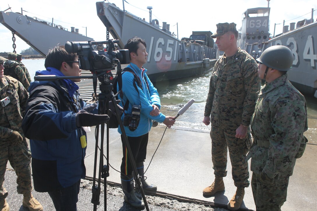 Lt. Col. William Arick, commanding officer, Combat Logistics Battalion 31, 31st Marine Expeditionary Unit (left) and Capt. Masanori Ide, Japanese Ground Self Defense Force liaison officer to the 31st MEU (right), speak to Reuters media in front of U.S. Navy landing craft docked here, March 27.  The 31st MEU and Amphibous Squadron 11 picked up Japanese utility repair vehicles from the port in Kessenuma and delivered food, water, comfort items and the vehicles to residents on this isolated island.  The island of Oshima has been cut off from the mainland since the earthquake and tsunami March 11.  The operation demonstrated the MEU’s expeditionary capabilities in ship-to-shore amphibious operations. Marines and Sailors of the 31st MEU are conducting humanitarian aid and disaster relief missions in northeast Japan assisting the Japanese Self Defense Forces in their ongoing operations.