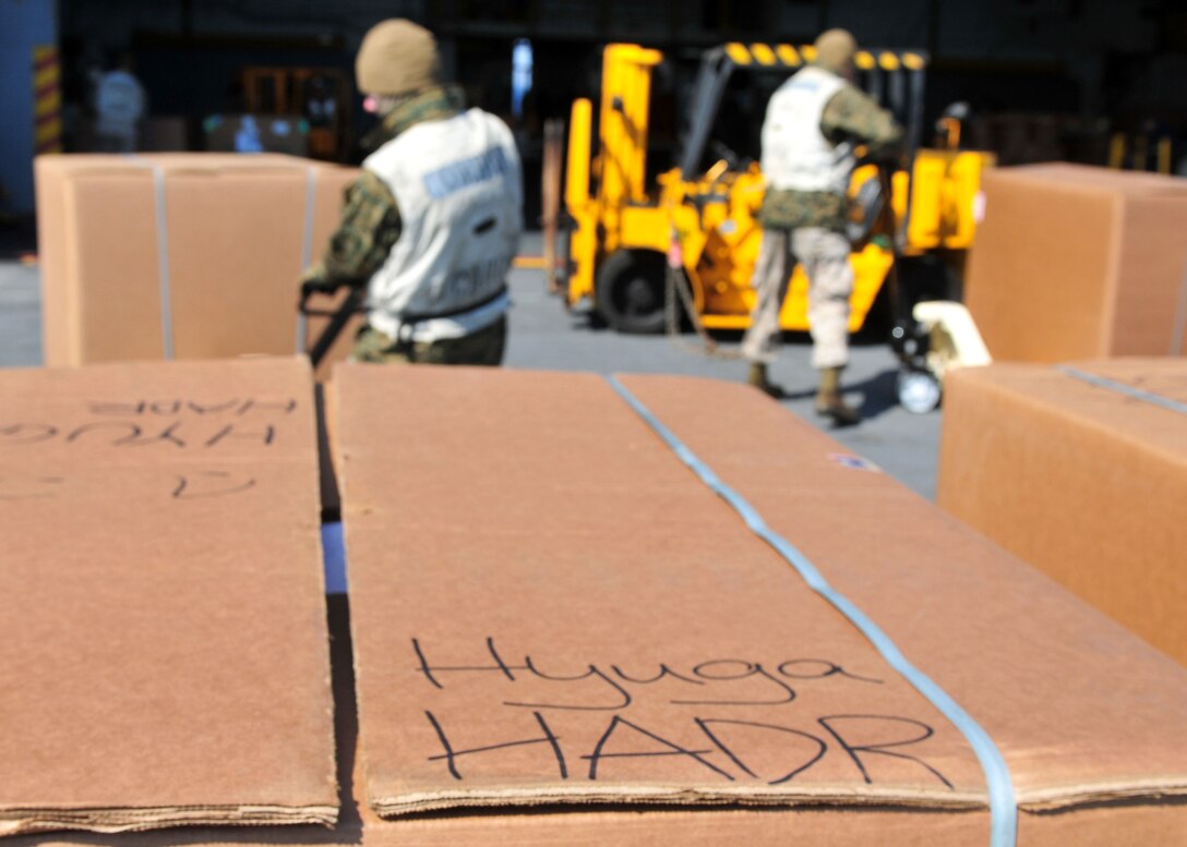 Marines assigned to the combat cargo department of the forward-deployed amphibious assault ship USS Essex (LHD 2) load humanitarian assistance and disaster relief supplies onto an aircraft elevator. Essex, with the embarked 31st Marine Expeditionary Unit, is currently operating off the coast of Kesennuma in northeastern Japan in support of Operation Tomodachi.