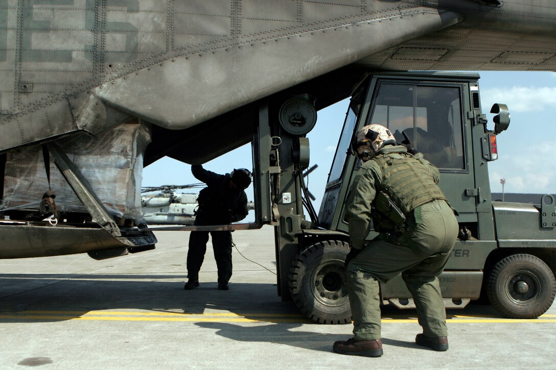 Staff Sgt. Terrance W. Clark (left), and Staff Sgt. Ian J. Huffman (right), crew chiefs with Marine Medium Helicopter Squadron 262 (Reinforced), 31st Marine Expeditionary Unit, direct a forklift as it unloads supplies from a CH-53E Super Stallion helicopter, March 29. The supplies were delivered to Misawa Japan, and used to support humanitarian aid and disaster relief operations currently in progress. The 31st MEU’s involvement is part of a larger U.S. government response, after a 9.0 earthquake and subsequent tsunami struck Japan causing widespread damage. The 31st MEU is ready to support our Japanese partners and to provide assistance when called upon.