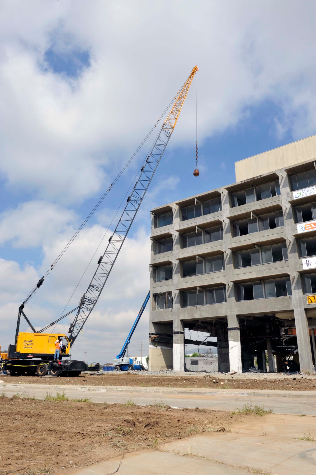 A 5,000-pound wrecking ball  is slammed into the roof from a crane operated by Col. Udo McGregor, 452nd Air Mobility Wing commander at a deconstruction ceremony here Tuesday, March 22nd.  The building demolition is one of many to make room for the 3.3 million dollar March LifeCare facility.  (Courtesy photo of Matthew Smith)