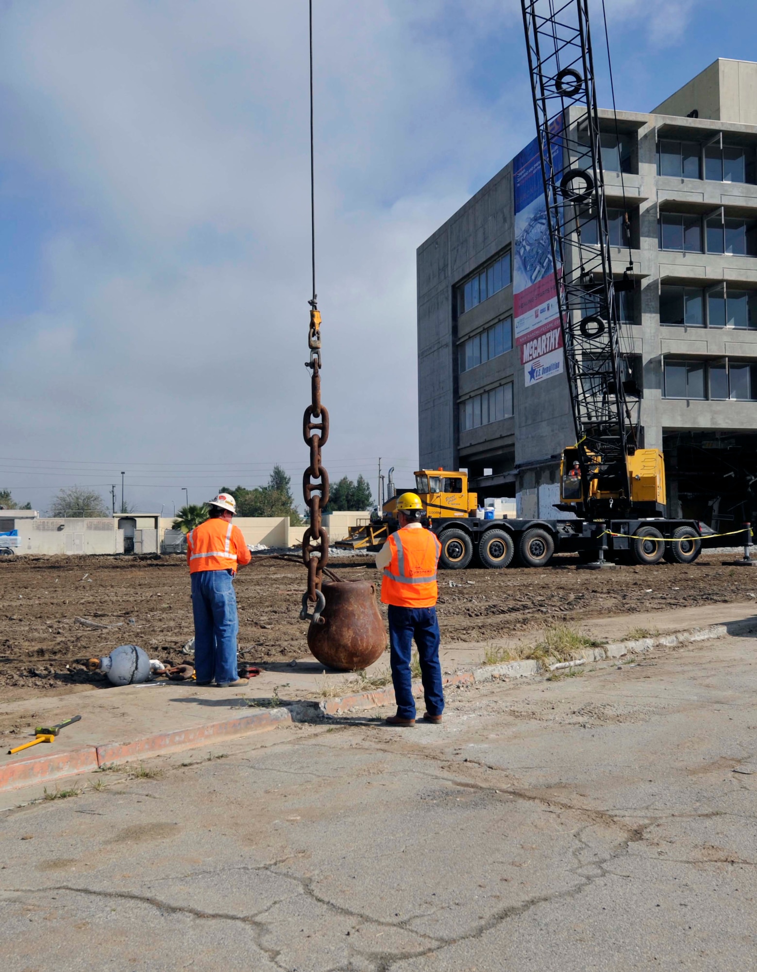 Two U.S. Demolition employees attach a 5,000-pound wrecking ball to a cable so a crane can lift the ball in preparation for deconstruction of the former March Air Force Base hospital building here Tuesday, March 22nd.  The demolition will make way for the 3.3 million dollar March LifeCare facility.  (Courtesy photo of Matthew Smith)