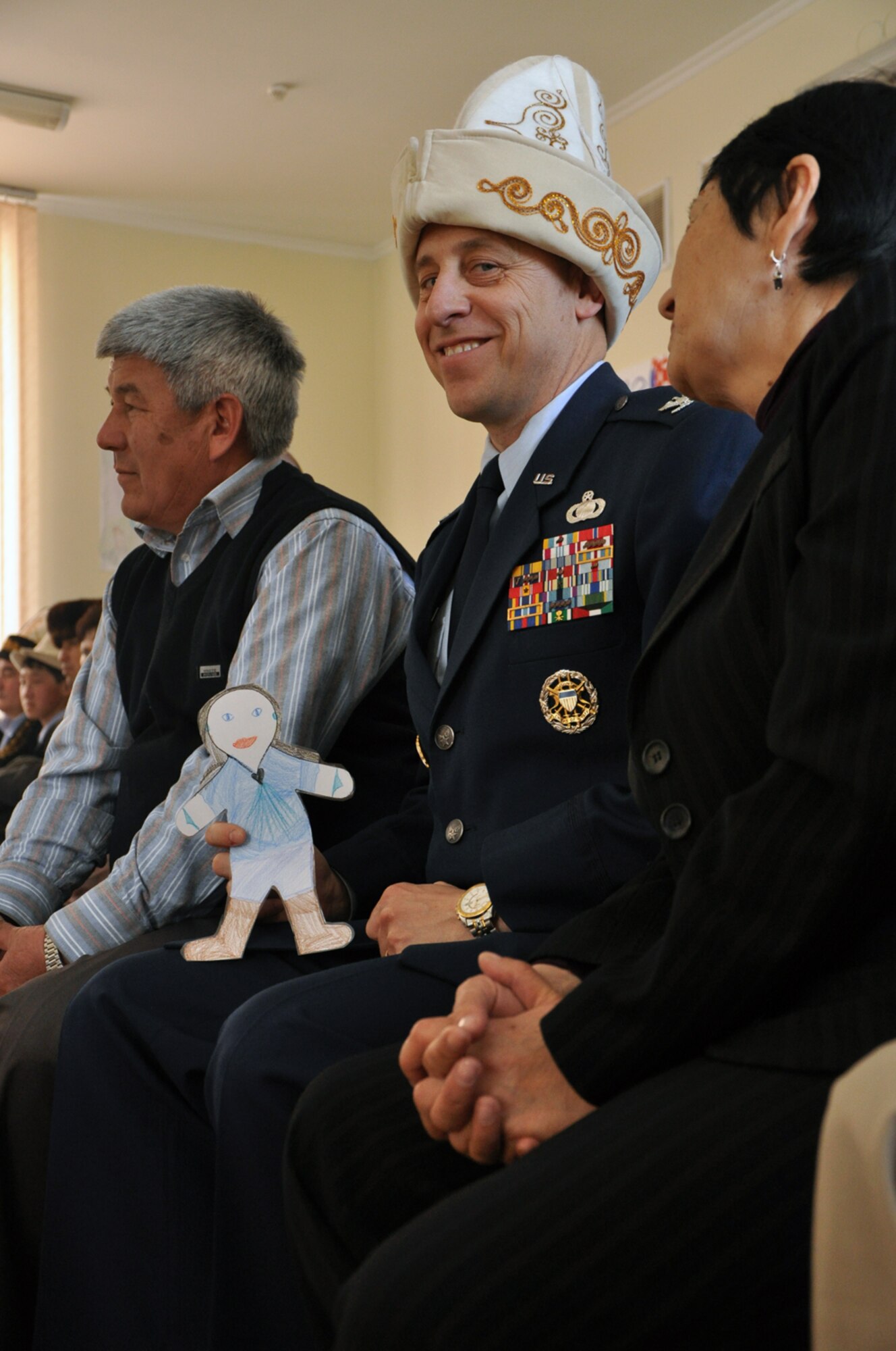 Flat Stanley watches the Kyrgyz New Year or Nooruz festivities at Birdik Village School with Col. David Zorzi, 376th Expeditionary Mission Support Group,Transit Center at Manas, Kyrgyzstan. Colonel Zorzi is wearing a traditional Kyrgyz headwear called a Kalpak which was presented to him at the school. Upon arriving at the Transit Center, Flat Stanley has been spotted participating in a number of Transit Center activities. Stanley is now safely back in his envelope and in the mail on his way home to North Carolina. (U.S. Air Force photo/Master Sgt. Daniel Nathaniel)