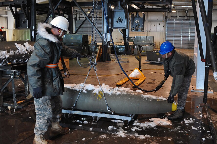 Two Airmen from the 28th Munitions Squadron, load a two thousand pound bomb in preparation for Operation Odyssey Dawn at Ellsworth Air Force Base, S.D., March 26, 2011.  With less than 48 hours of notice, members of the 28th Bomb Wing generated hundreds of weapons and subsequently launching several aircraft. (U.S. Air Force photo/Senior Airman Kasey Close)