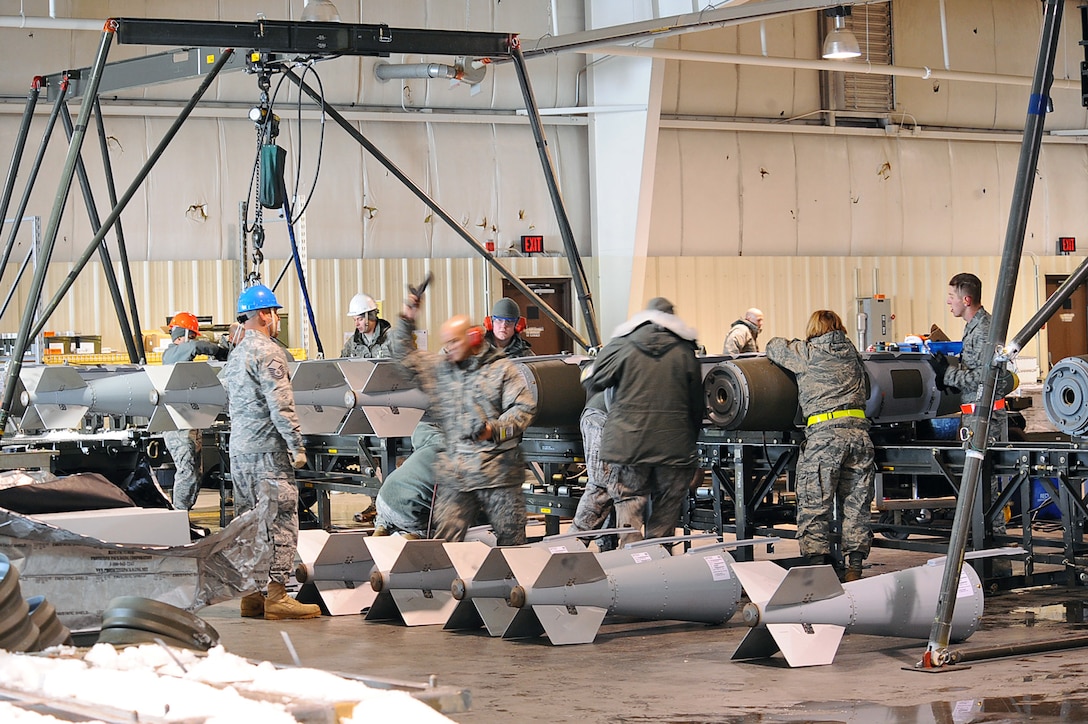 Members of Ellsworth Air Force Base 28th Munitions Squadron, assemble two thousand pound bombs in preparation for Operation Odyssey Dawn at Ellsworth Air Force Base, S.D., March 26, 2011. Ellsworth Airmen generated several aircraft and hundreds of weapons to provide the combat configuration needed halfway around the globe. (U.S. Air Force photo/Senior Airman Kasey Close)