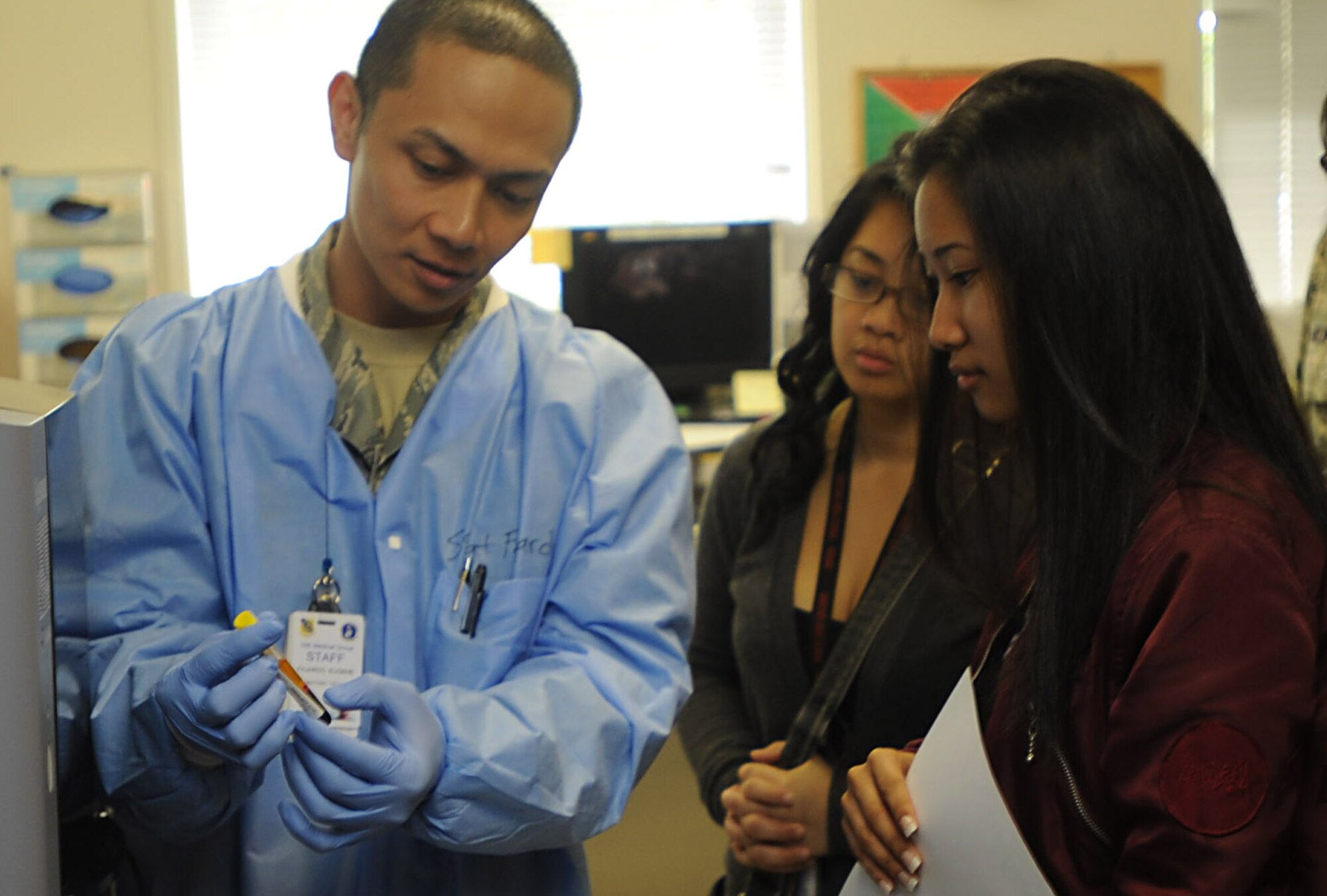 Staff Sgt. Eugene Fajardo, Labratory Technician with the 15th Medical Group, shows a blood sample to Radford High School students Mar. 24 during a tour of various facilities at Joint Base Pearl Harbor-Hickam, Hawaii. During the visit, the RHS students visited various locations on base including the C-17 Operations building, C-17 simulator, fitness center, and the child development center. (U.S. Air Force photo by Airman 1st Class Lauren Main)