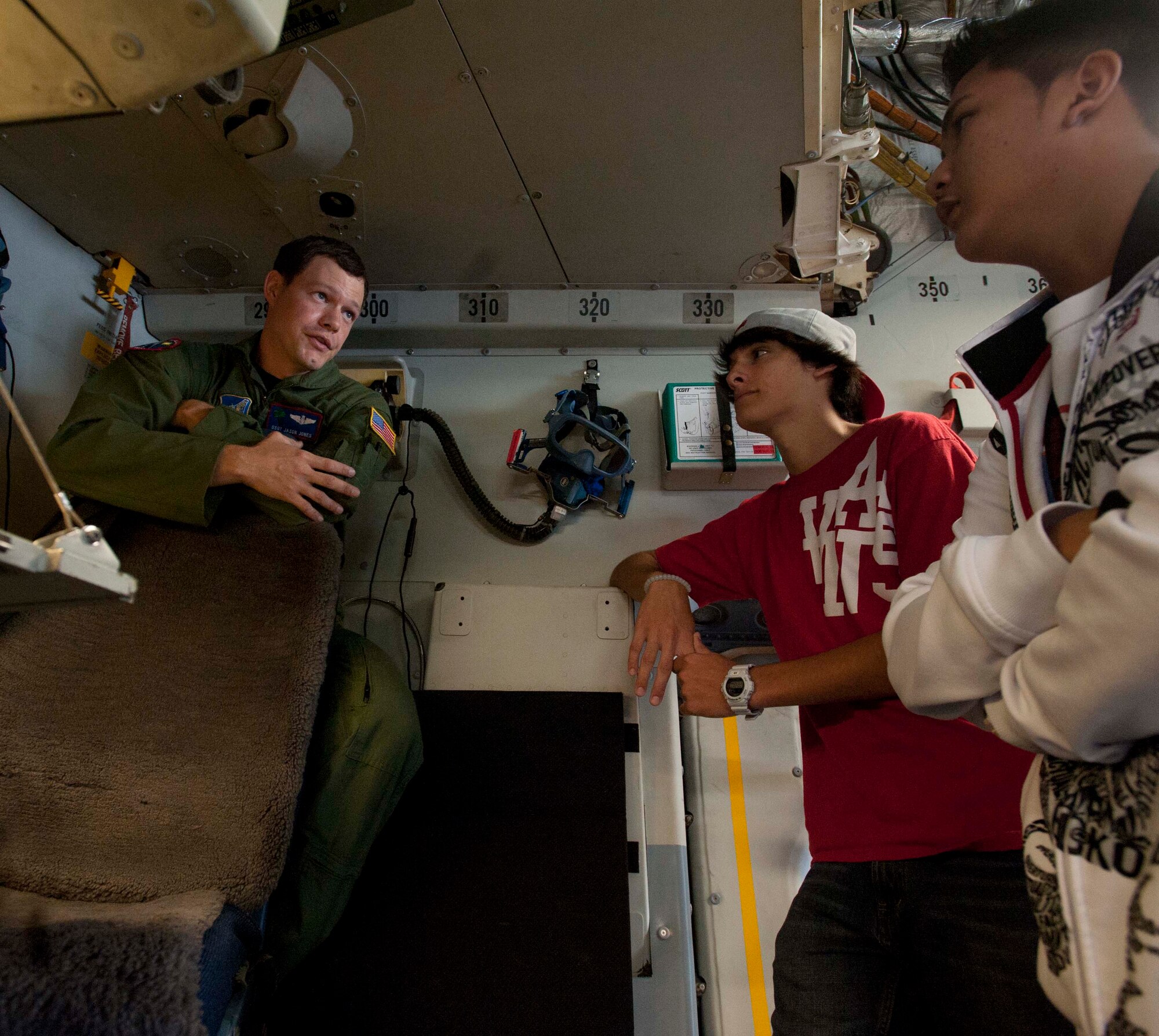 Staff Sgt. Jason Jones, 15th Operations Support Squadron loadmaster instructor, discusses loadmaster responsibilities with Miguel Lozada (center) and John Christian Hew Len,  Radford High School students, Mar. 24 at Joint Base Pearl Harbor-Hickam, Hawaii. During the visit, the RHS students visited various locations on base including the C-17 Operations building, C-17 simulator, fitness center, and the child development center. (U.S. Air Force photo by Staff Sgt. Nathan Allen)