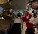 Staff Sgt. Jason Jones, 15th Operations Support Squadron loadmaster instructor, discusses loadmaster responsibilities with Miguel Lozada (center) and John Christian Hew Len,  Radford High School students, Mar. 24 at Joint Base Pearl Harbor-Hickam, Hawaii. During the visit, the RHS students visited various locations on base including the C-17 Operations building, C-17 simulator, fitness center, and the child development center. (U.S. Air Force photo by Staff Sgt. Nathan Allen)