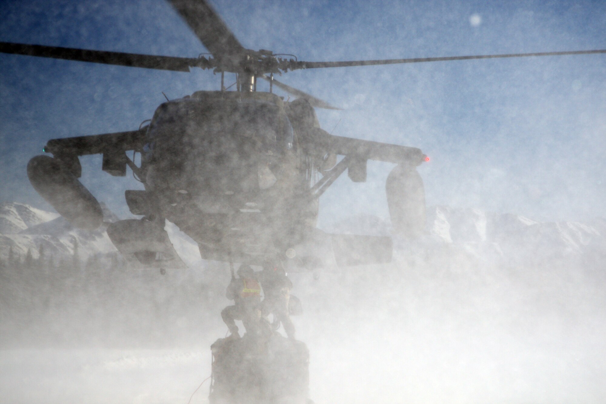 Soldiers brave sub-zero wind chills and stinging snow caused by the rotor wash of a 207th Aviation Regiment, Alaska Army National Guard, UH-60 Blackhawk during training at Landing Zone Ranger.  Soldiers were familiarized with establishing a helicopter landing zone and basic sling load operations, which included hand and arm signals, hookup and release procedures, and preparation of an A-22 Cargo Bag for sling load utilizing a 10,000 pound
sling set and a 5,000 pound cargo net

