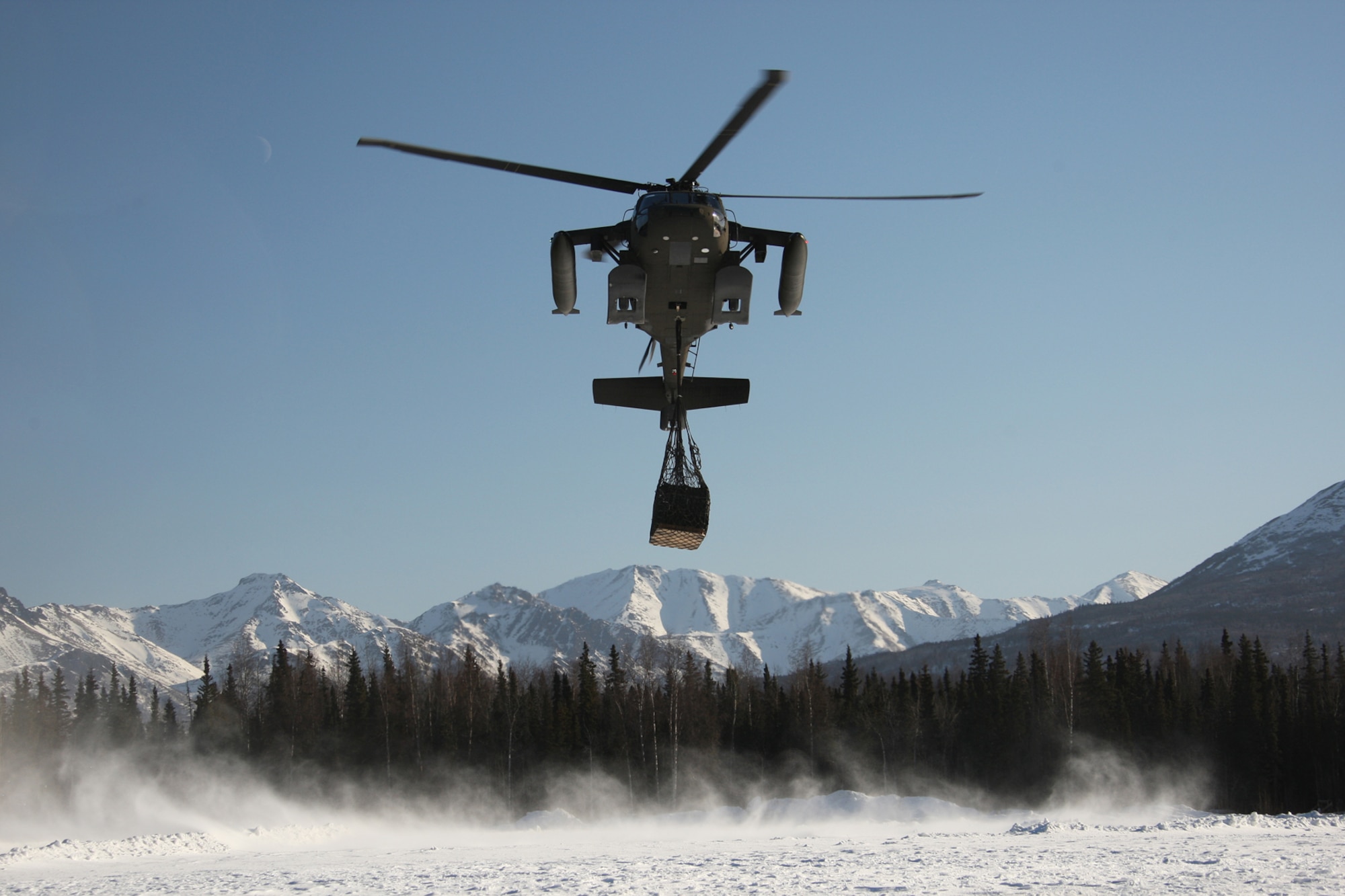 An Alaska Army National Guard UH-60 Blackhawk prepares to lower cargo at LZ Ranger.  Helicopters play a major role in delivering munitions and supplies to Soldiers in forward operating areas.