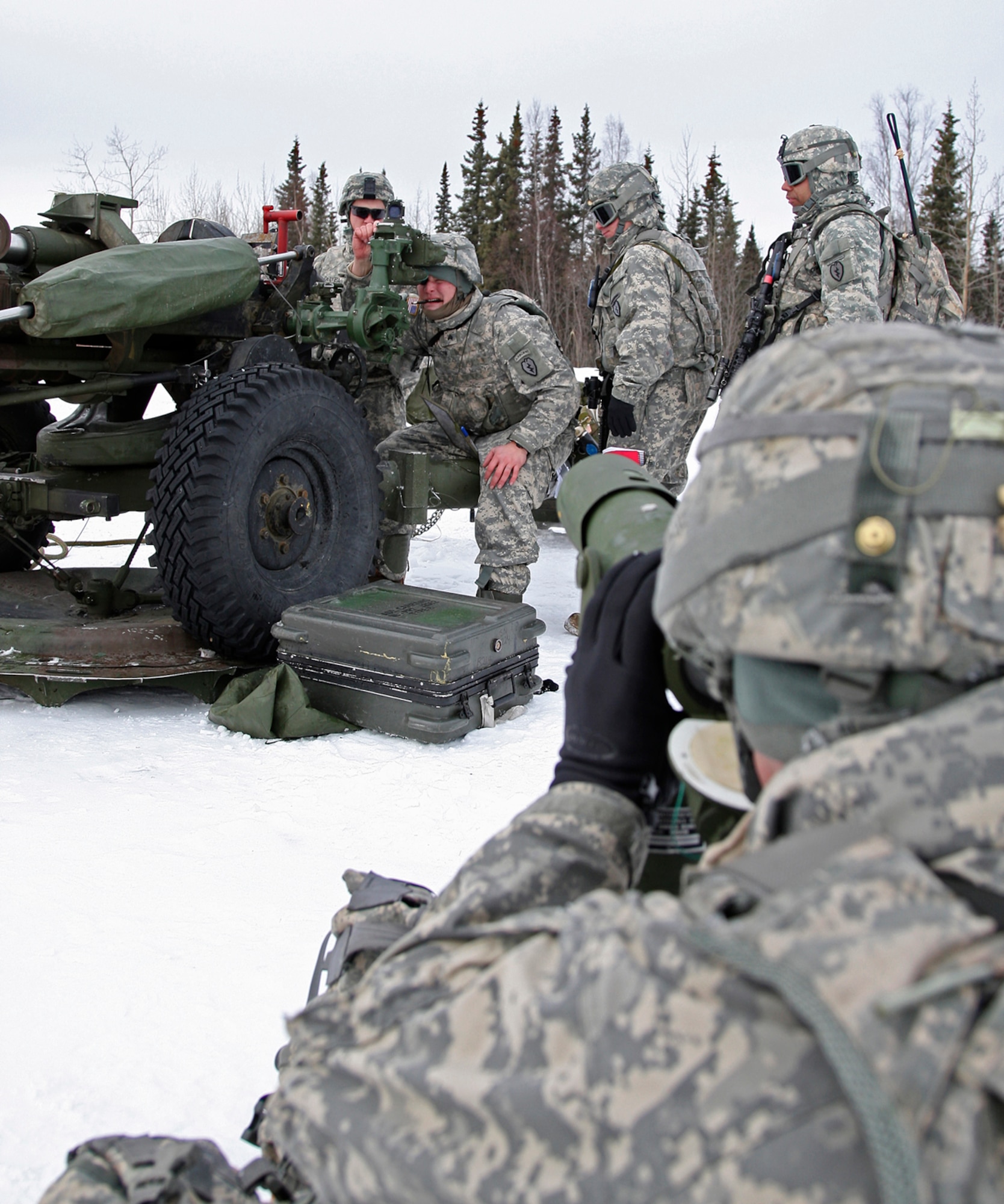 A gun crew prepares a M119A2 Howitzer for firing.  The M119 is currently fielded with all regular Army light divisions and is routinely airdropped in airborne operations and slingloaded under Chinook or UH-60 Black Hawk helicopters in air assault operations.
